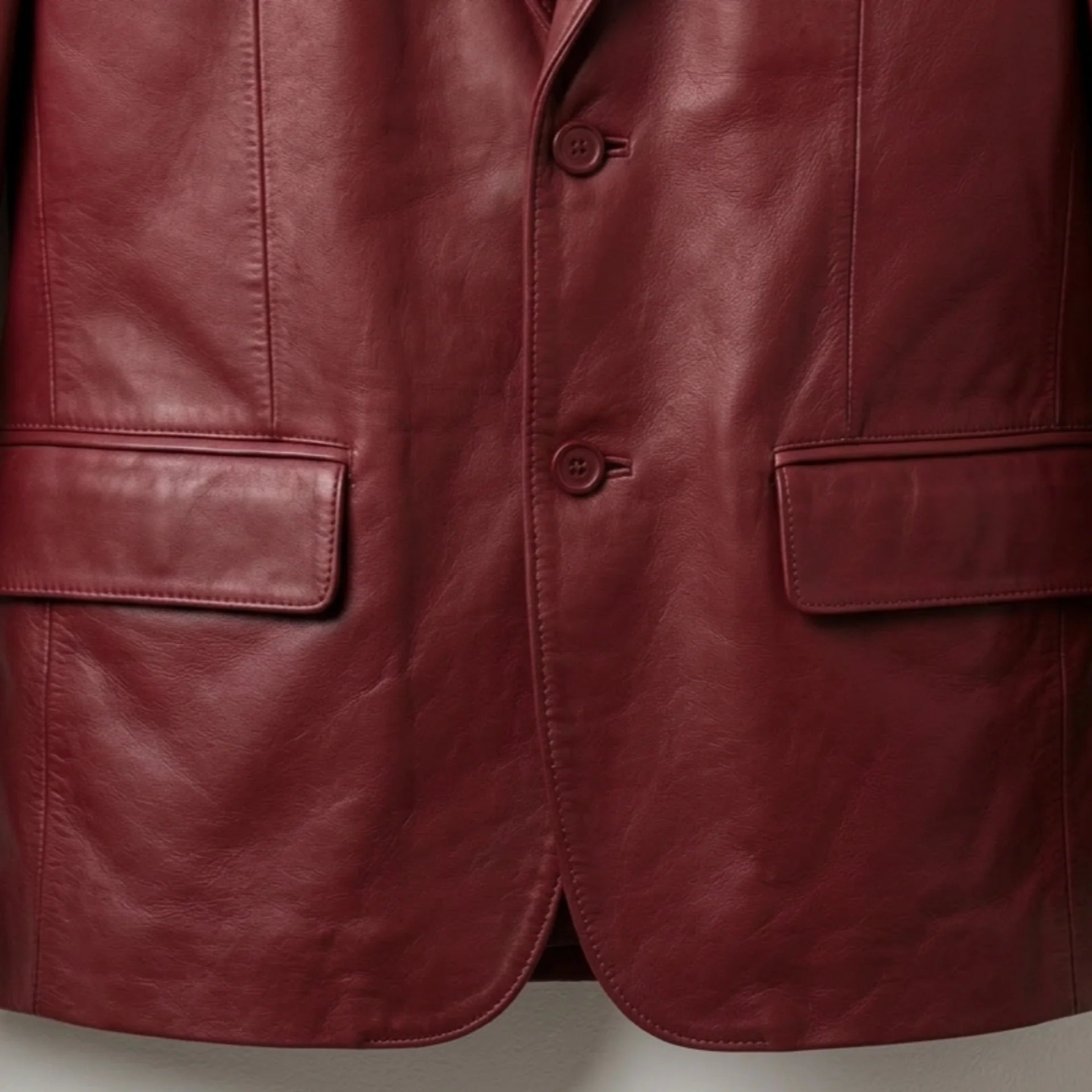 Front buttons and flap pockets on men’s red leather blazer
