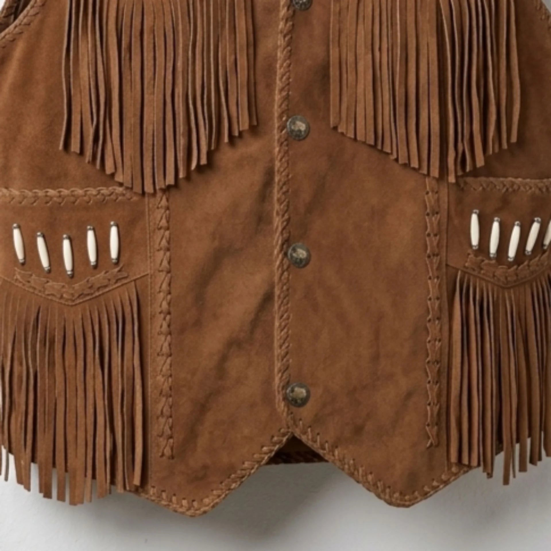 Brown leather vest with fringes and buttons on a white background