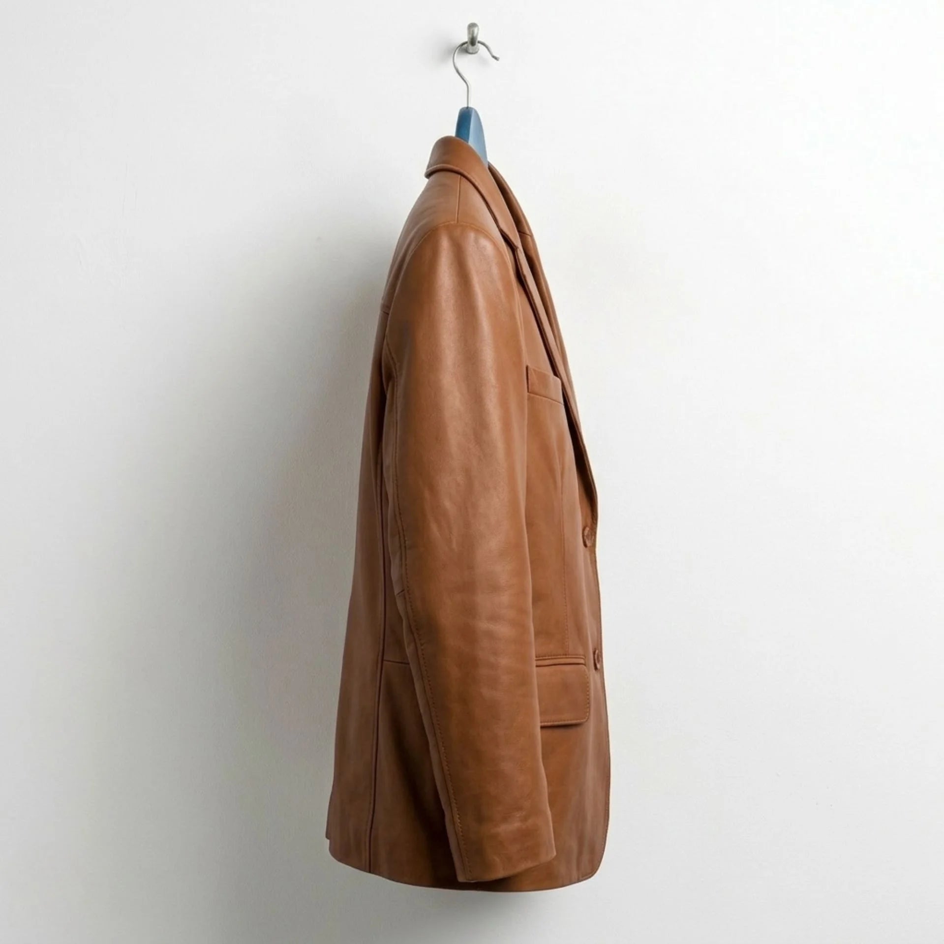 Side profile of men's tan leather blazer with tailored fit.