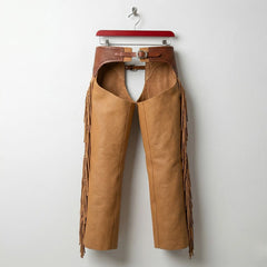 Back view of men's tan cowboy leather chaps showing fringe along outer legs