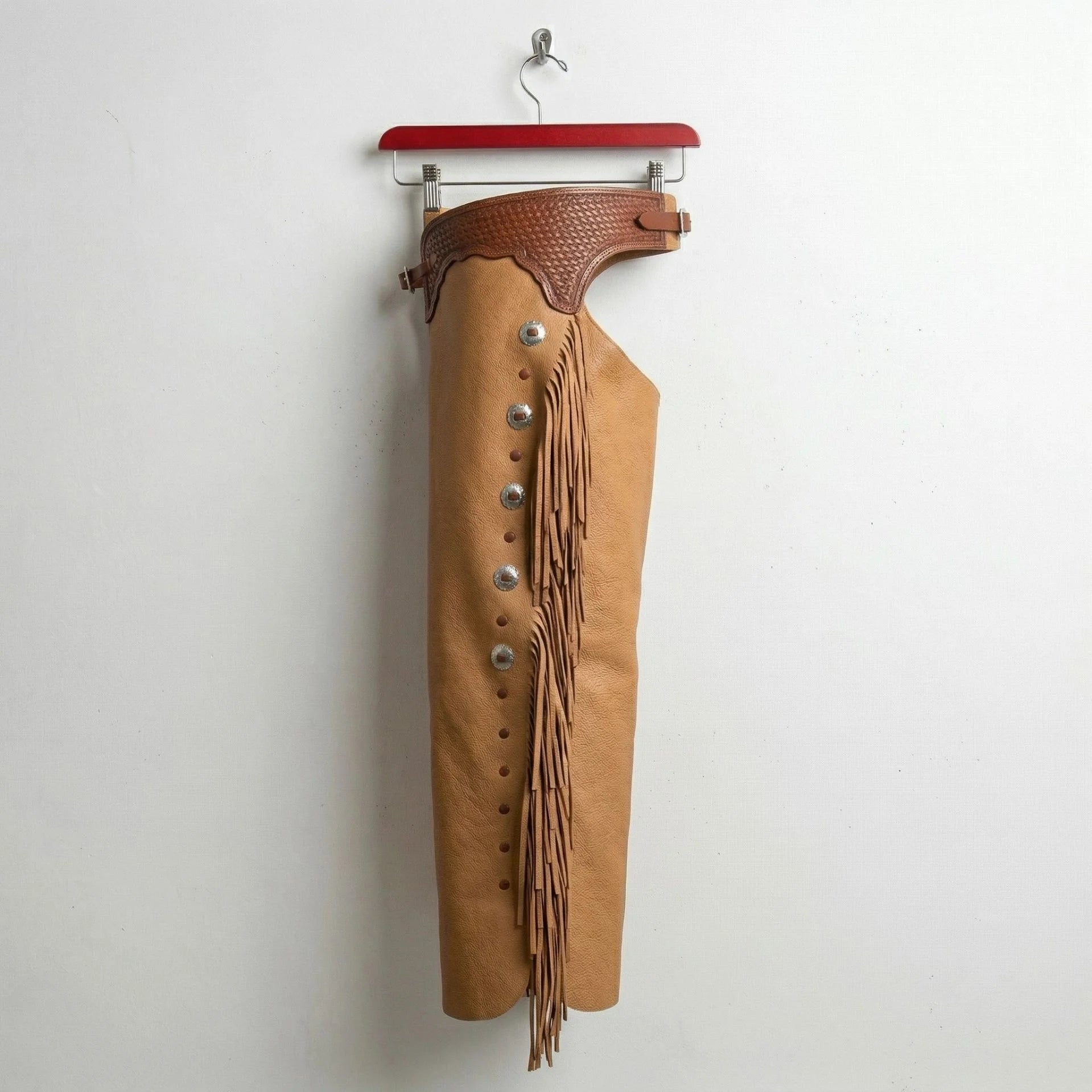 Opposite side view of men's tan fringe riding chaps with concho detail