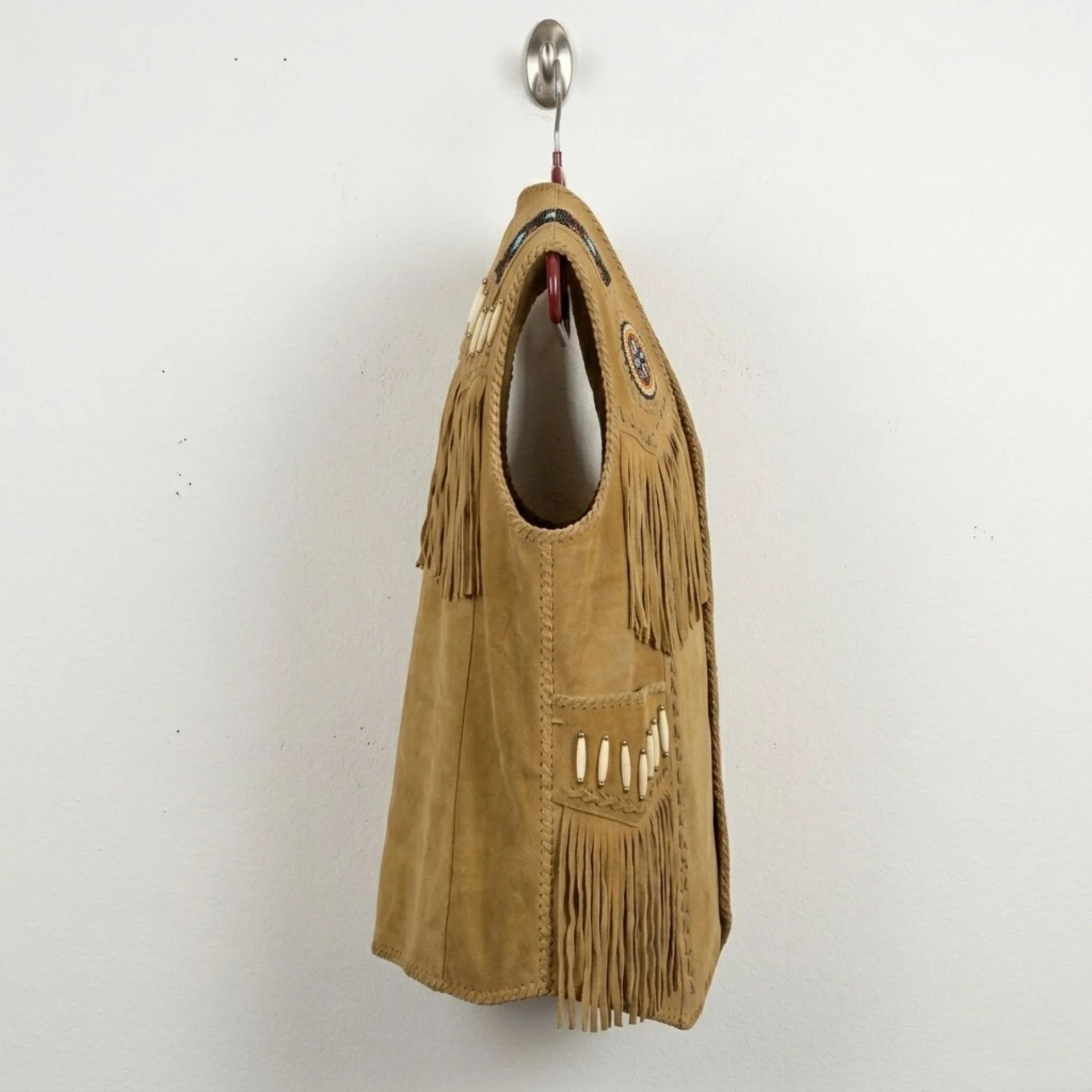 Side profile of men's tan suede fringe western vest.