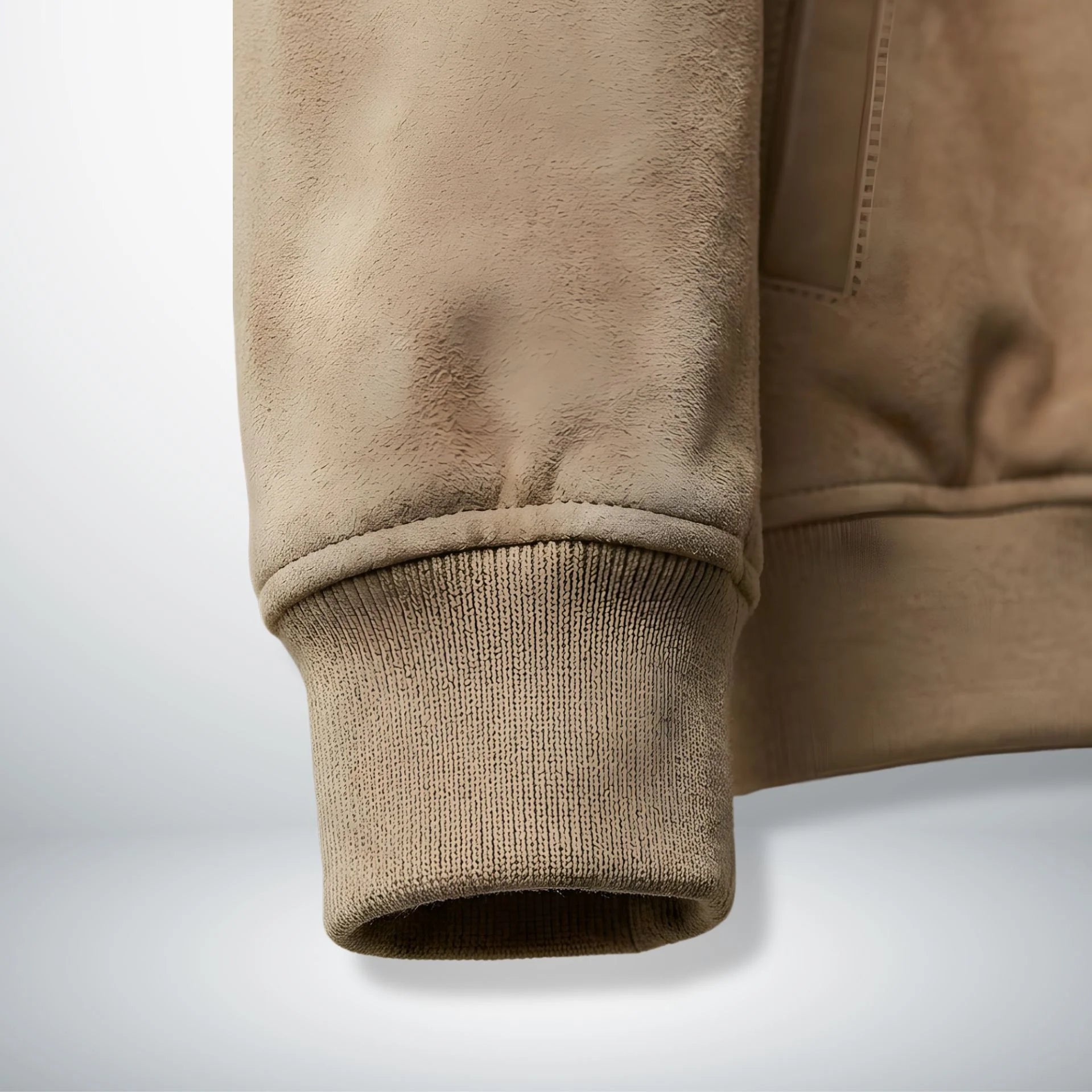 Detail of ribbed cuff and suede sleeve on men's tan leather bomber jacket.