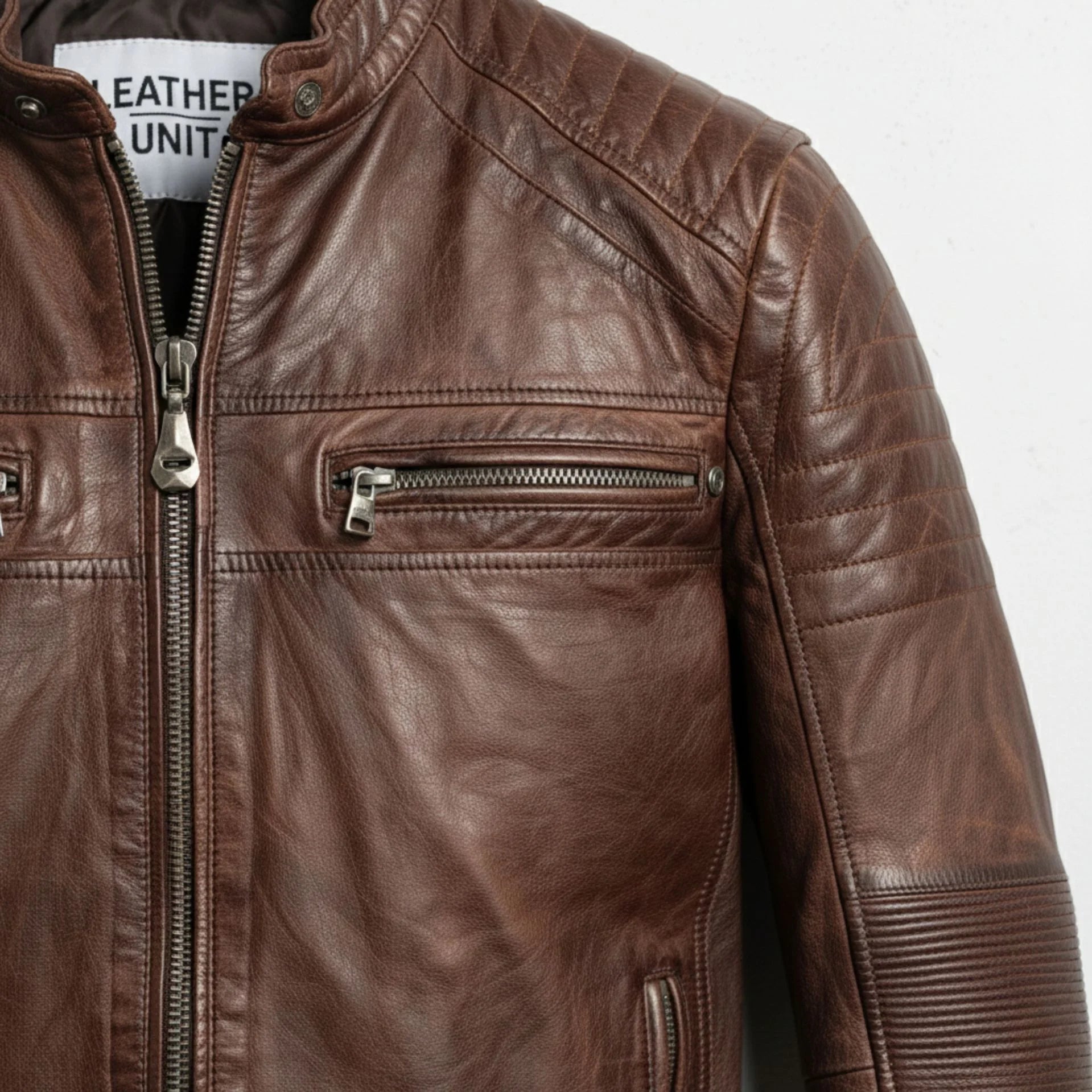 detail of quilted shoulder and chest zip pocket on men's vintage brown biker jacket.