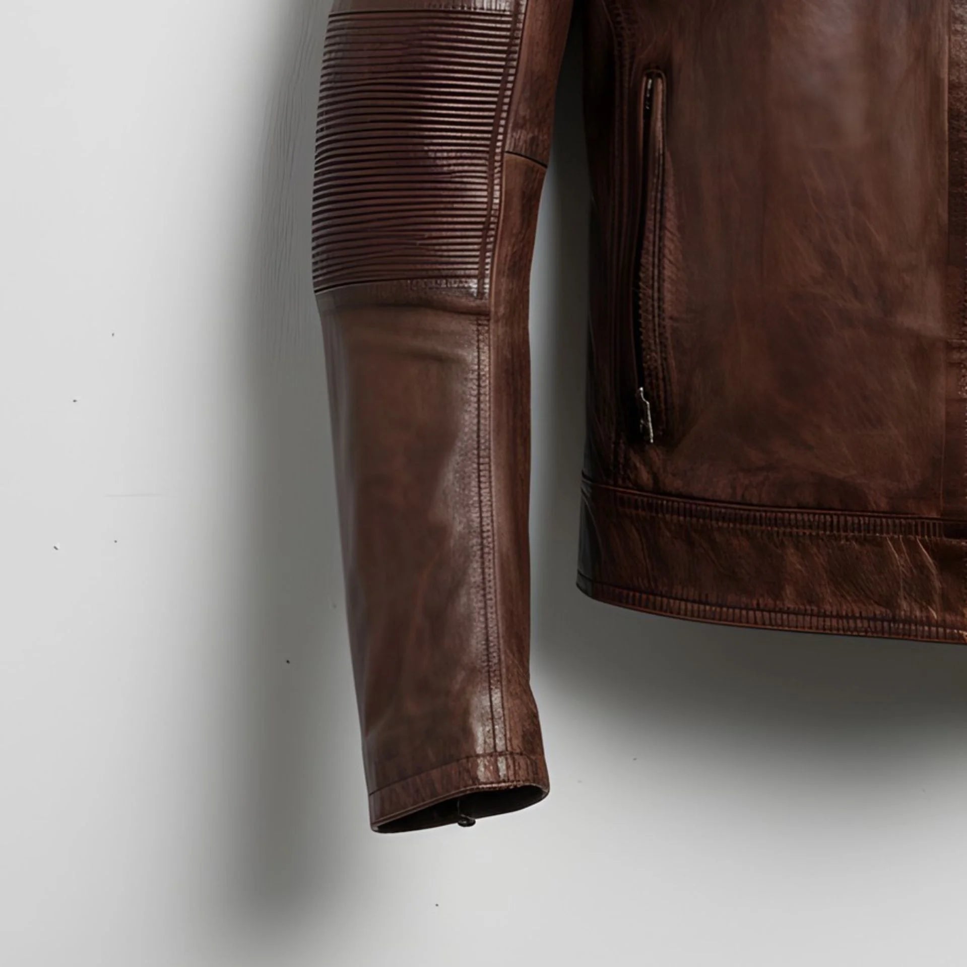 close up of ribbed elbow panel and side zip pocket on men's brown cafe racer leather jacket.