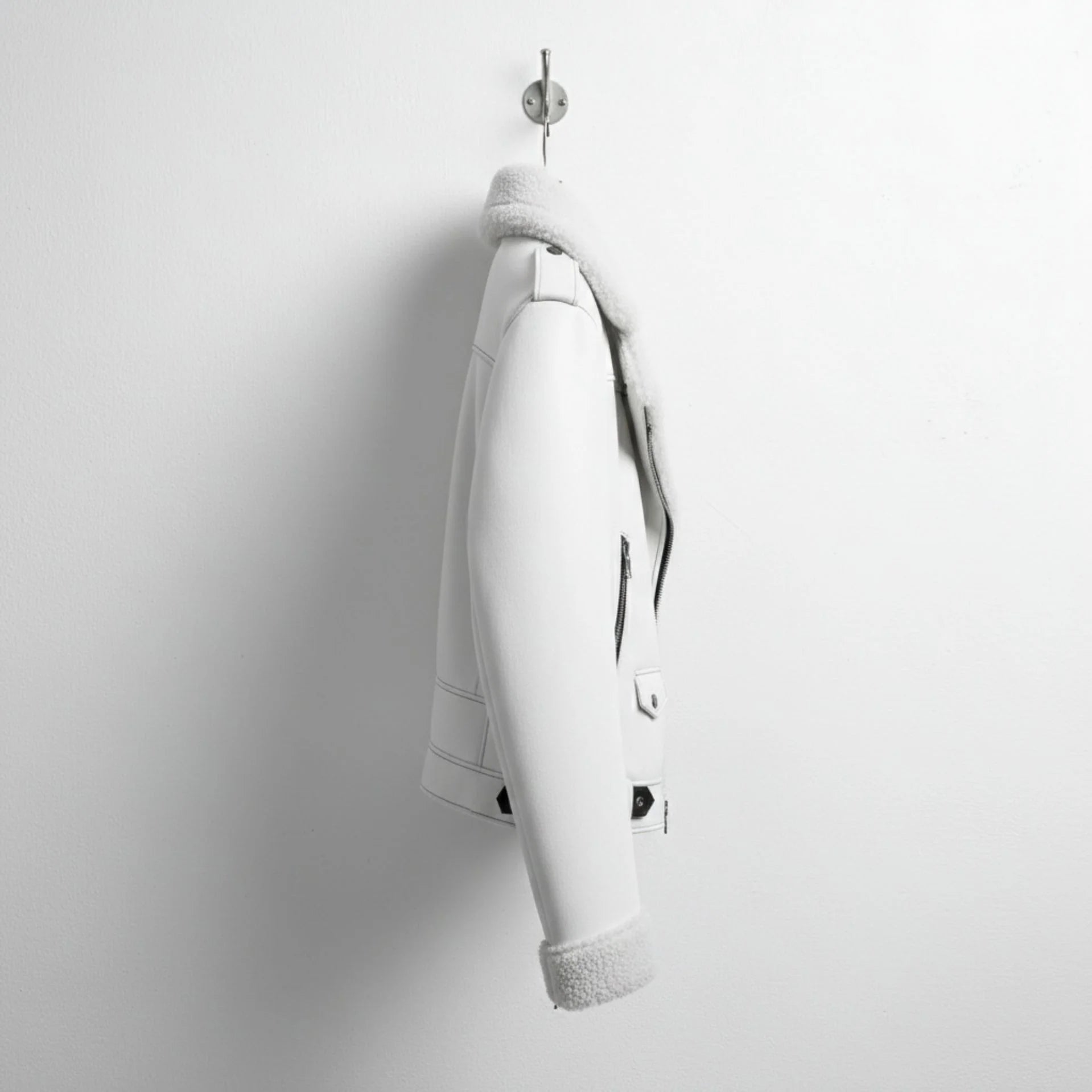 side profile mens white shearling aviator jacket hanging on wall.
