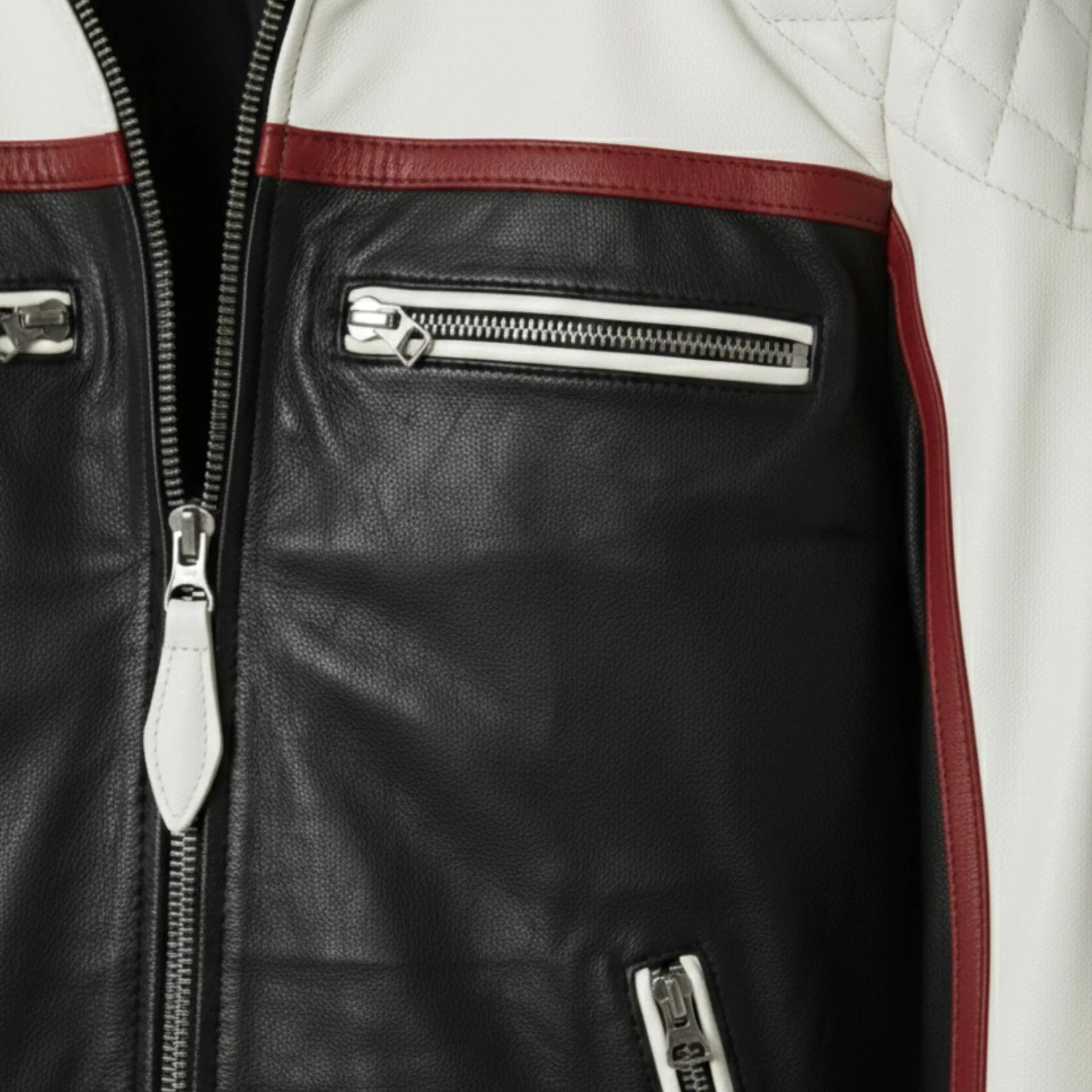 detail of chest zipper pockets and red stripe on men's white and black moto jacket.