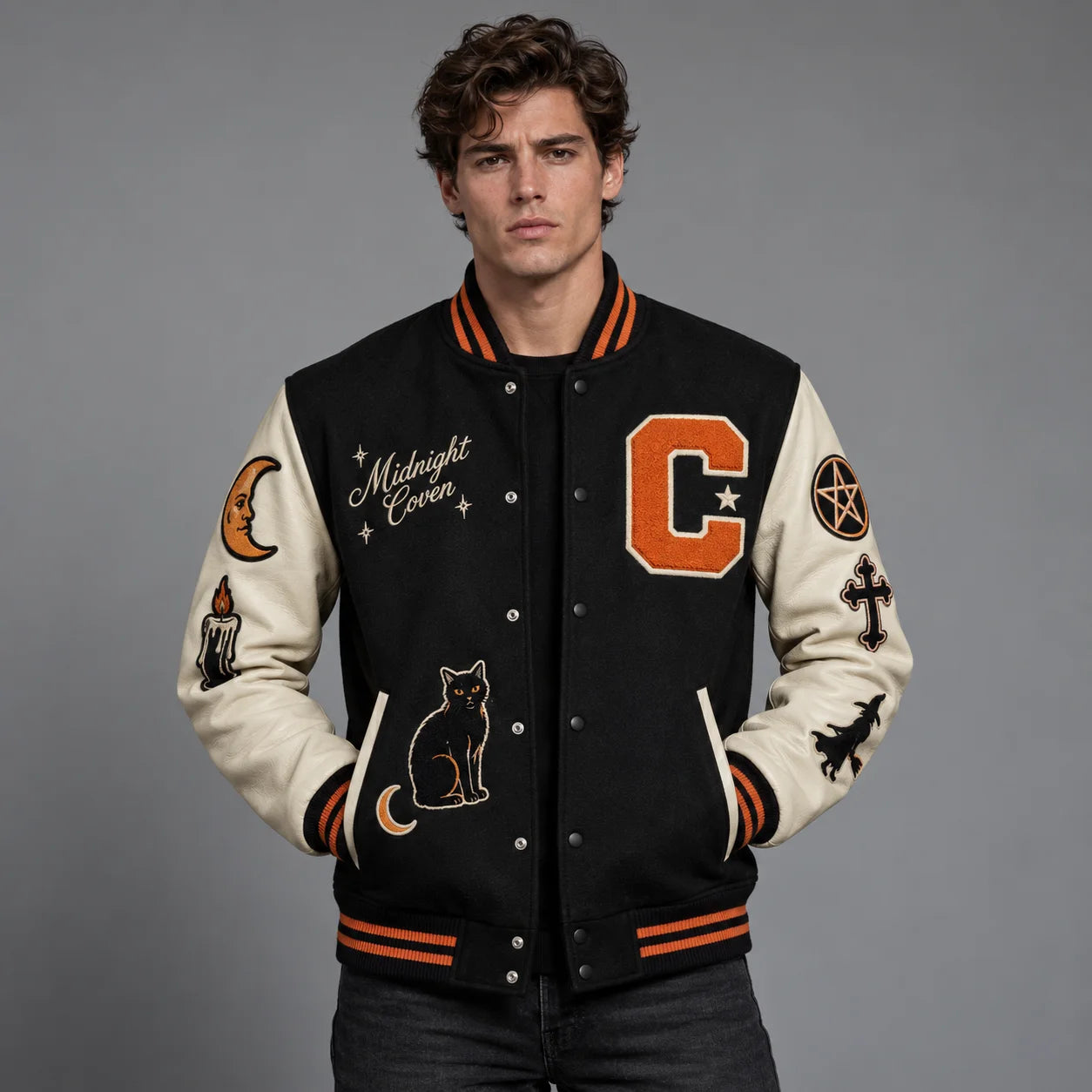 Studio front view of Midnight Coven Halloween varsity jacket with cream leather sleeves, black cat and orange C patch