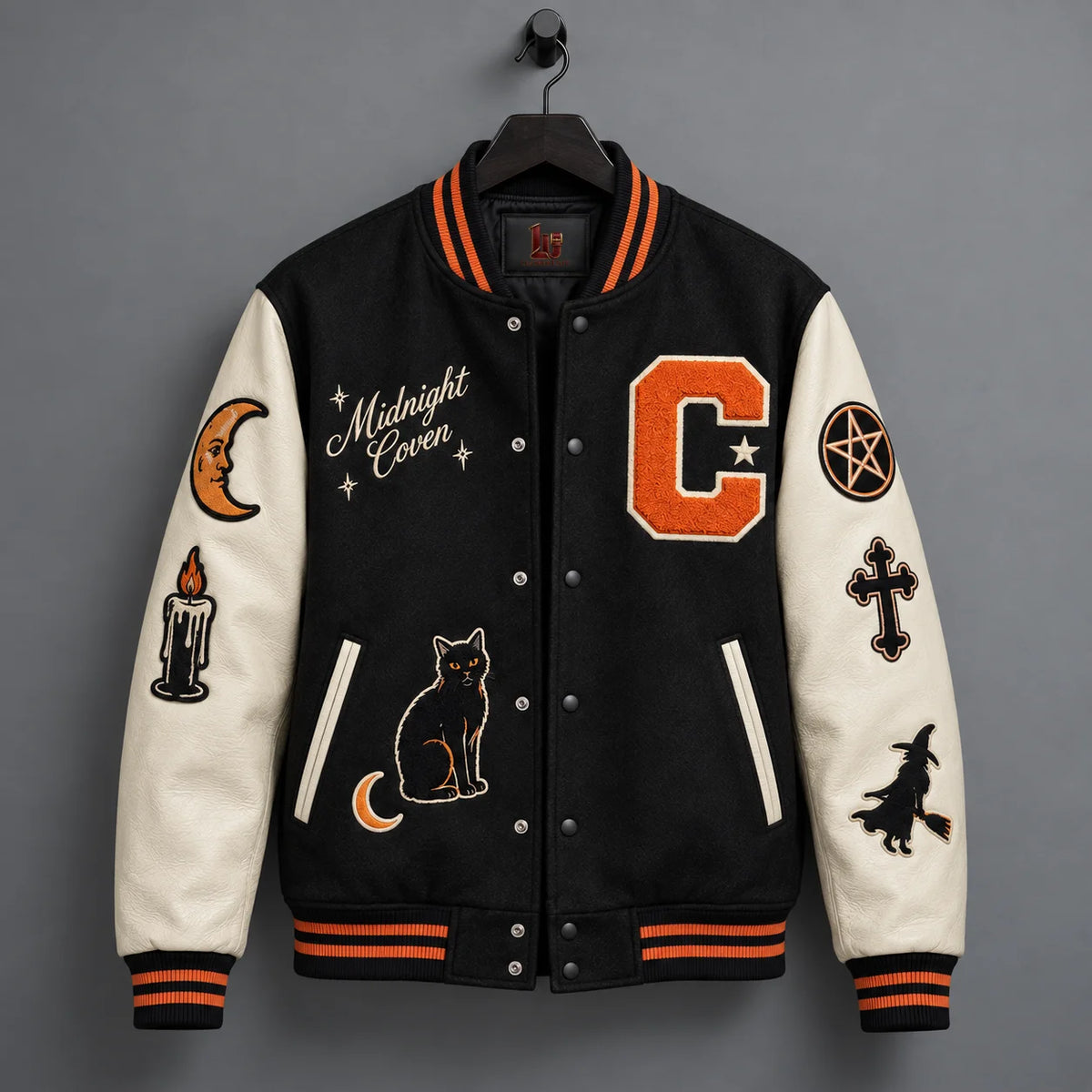 Hanging front view of Midnight Coven varsity jacket with black polyester body and cream genuine leather sleeves