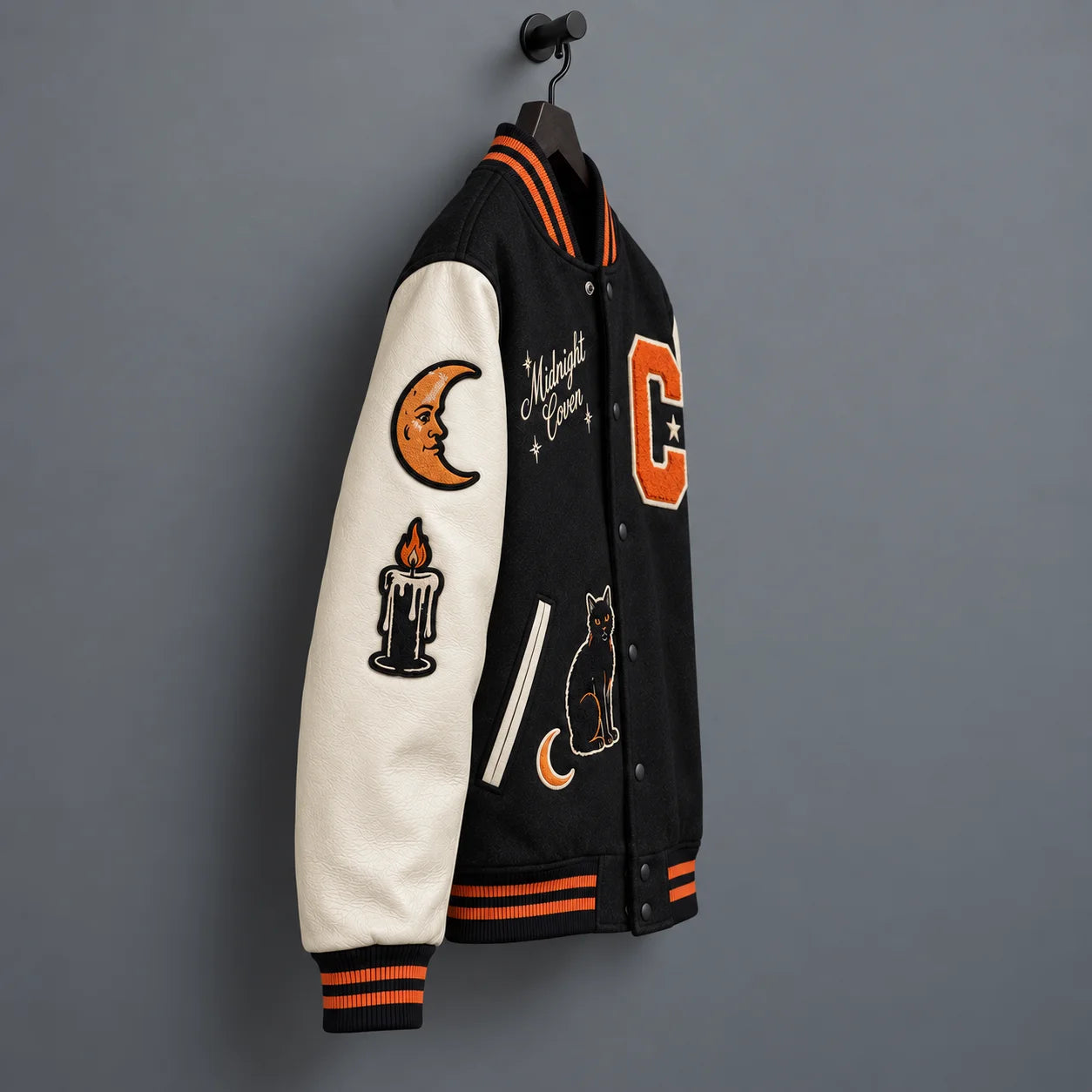 Side angle of Midnight Coven jacket showing cream leather sleeve with crescent moon and candle embroidered patches
