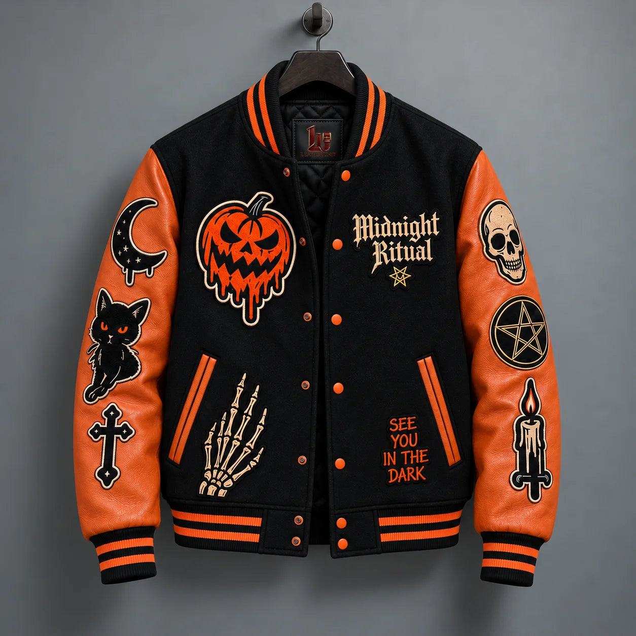 Hanging front view of Midnight Ritual varsity jacket with snap closure, striped trims and Halloween embroidery
