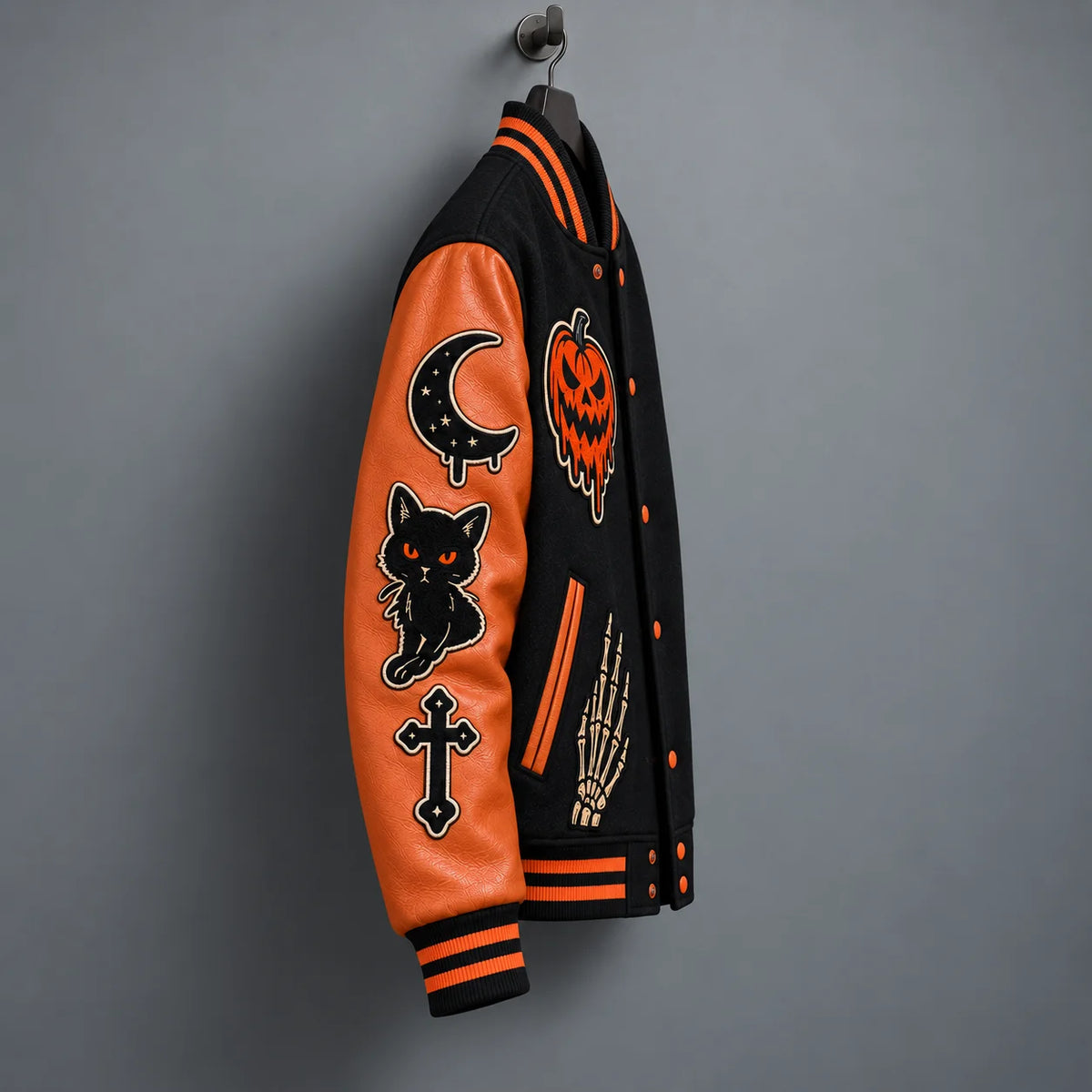 Side view of burnt orange varsity sleeve showing crescent moon, black cat and cross embroidered Halloween patches