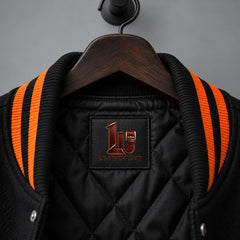 Close-up of black quilted lining and black-orange rib collar on Night Watch Halloween varsity jacket