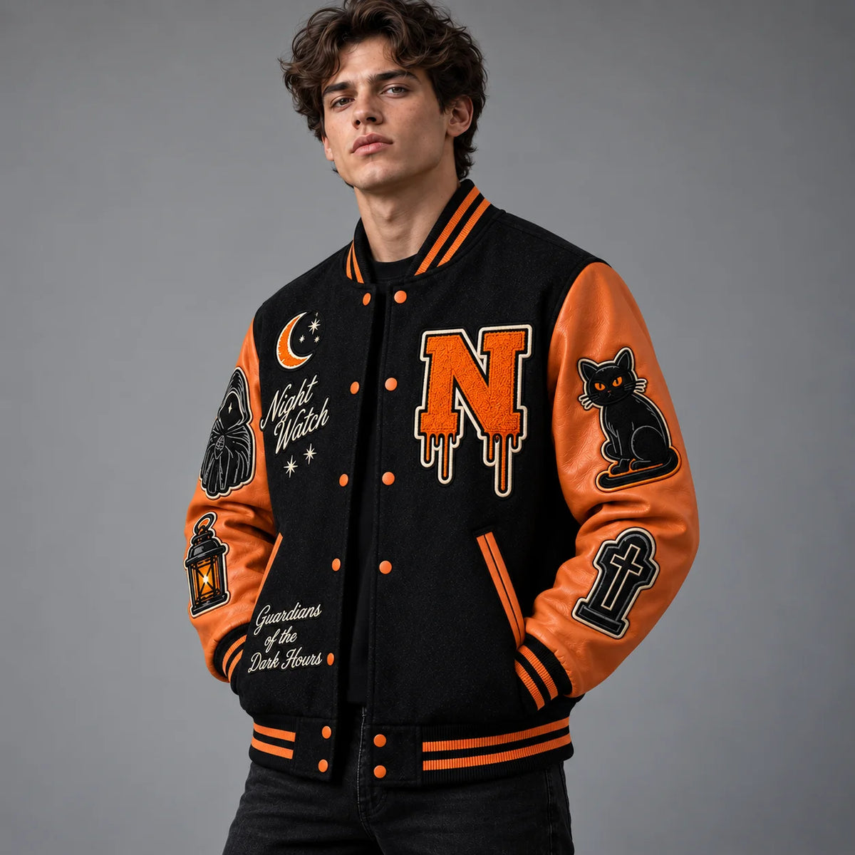 Three-quarter view of black and burnt orange Halloween varsity jacket showing cat, gravestone and Night Watch patches