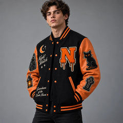 Three-quarter view of black and burnt orange Halloween varsity jacket showing cat, gravestone and Night Watch patches