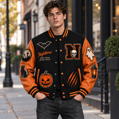 Outdoor front view of Nightborn black Halloween varsity jacket with orange genuine leather sleeves and embroidered patches