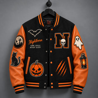 Hanging front view of black Halloween varsity jacket with genuine orange leather sleeves and matte-orange snaps