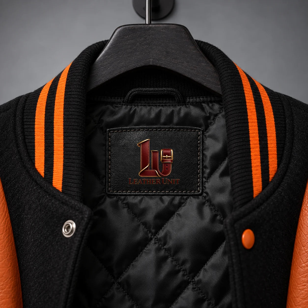 Collar close-up of Nightborn jacket showing black quilted lining, embroidered label and orange-black rib-knit trim