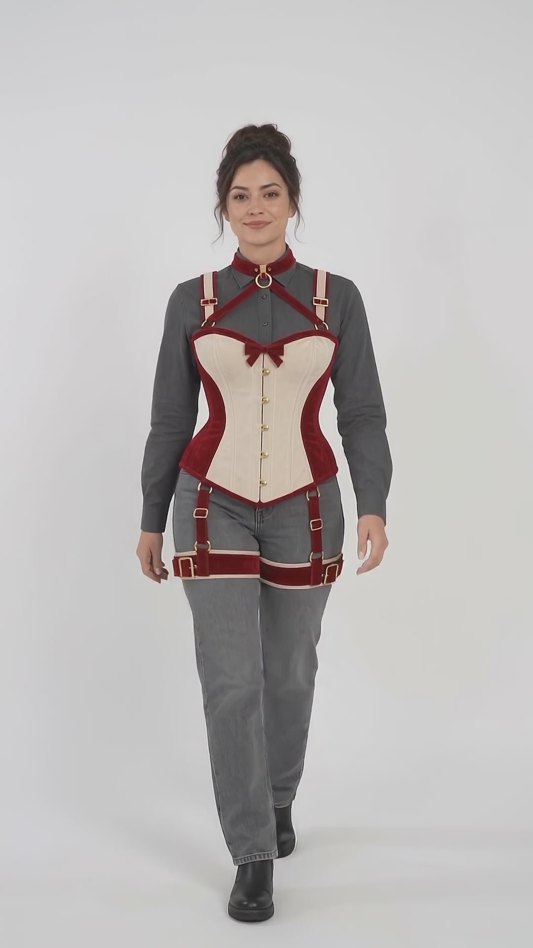 Product video presenting the cranberry-red and ivory velvet corset harness with gold-tone hardware and coordinated thigh straps.