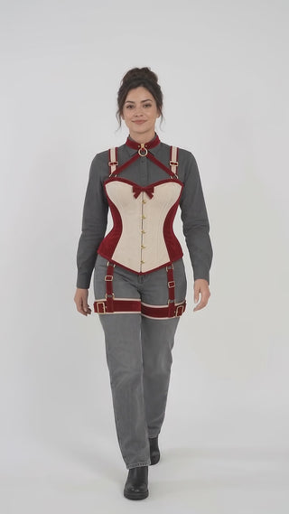 Product video presenting the cranberry-red and ivory velvet corset harness with gold-tone hardware and coordinated thigh straps.