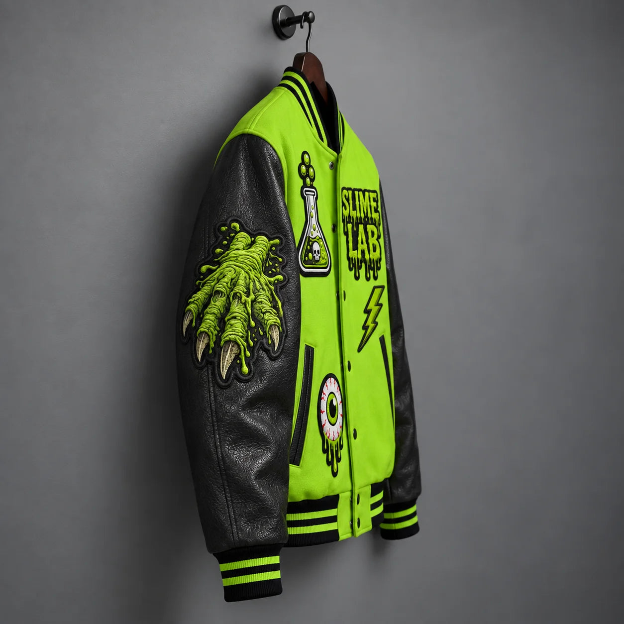 Side hanger view highlighting dark graphite leather sleeve with acid-green slime monster-hand embroidery