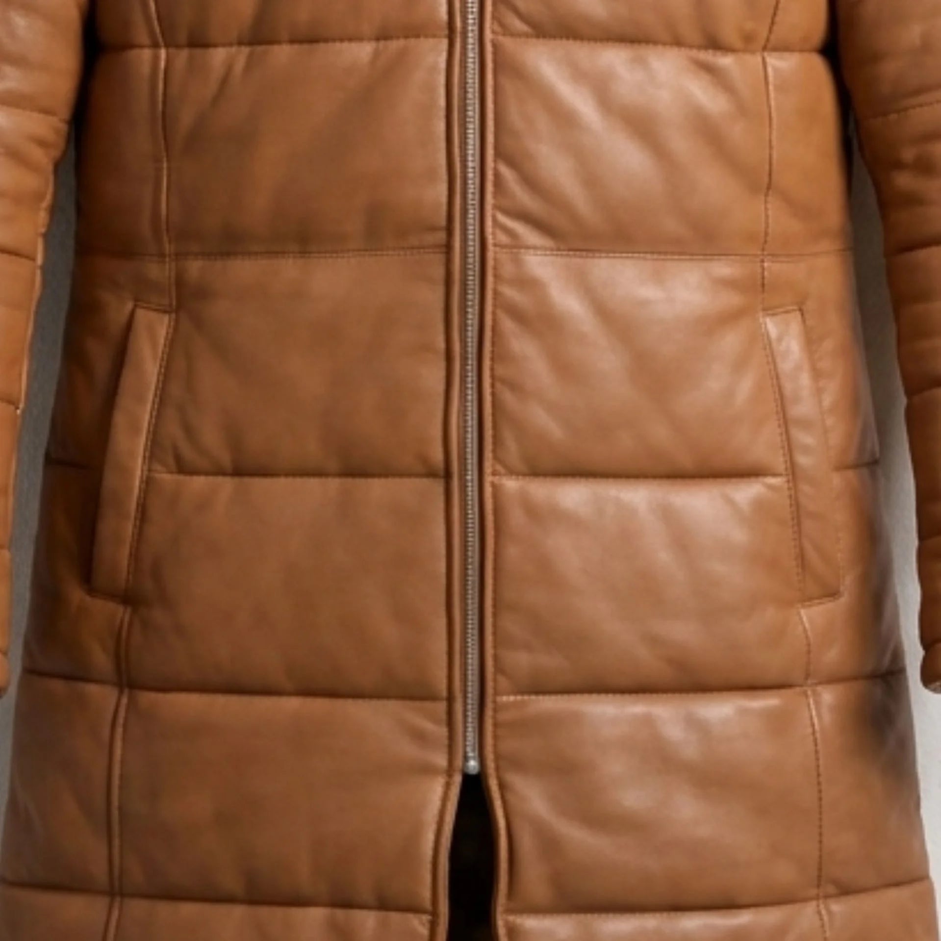 Close-up of front pockets and heavy-duty zipper on tan leather puffer coat
