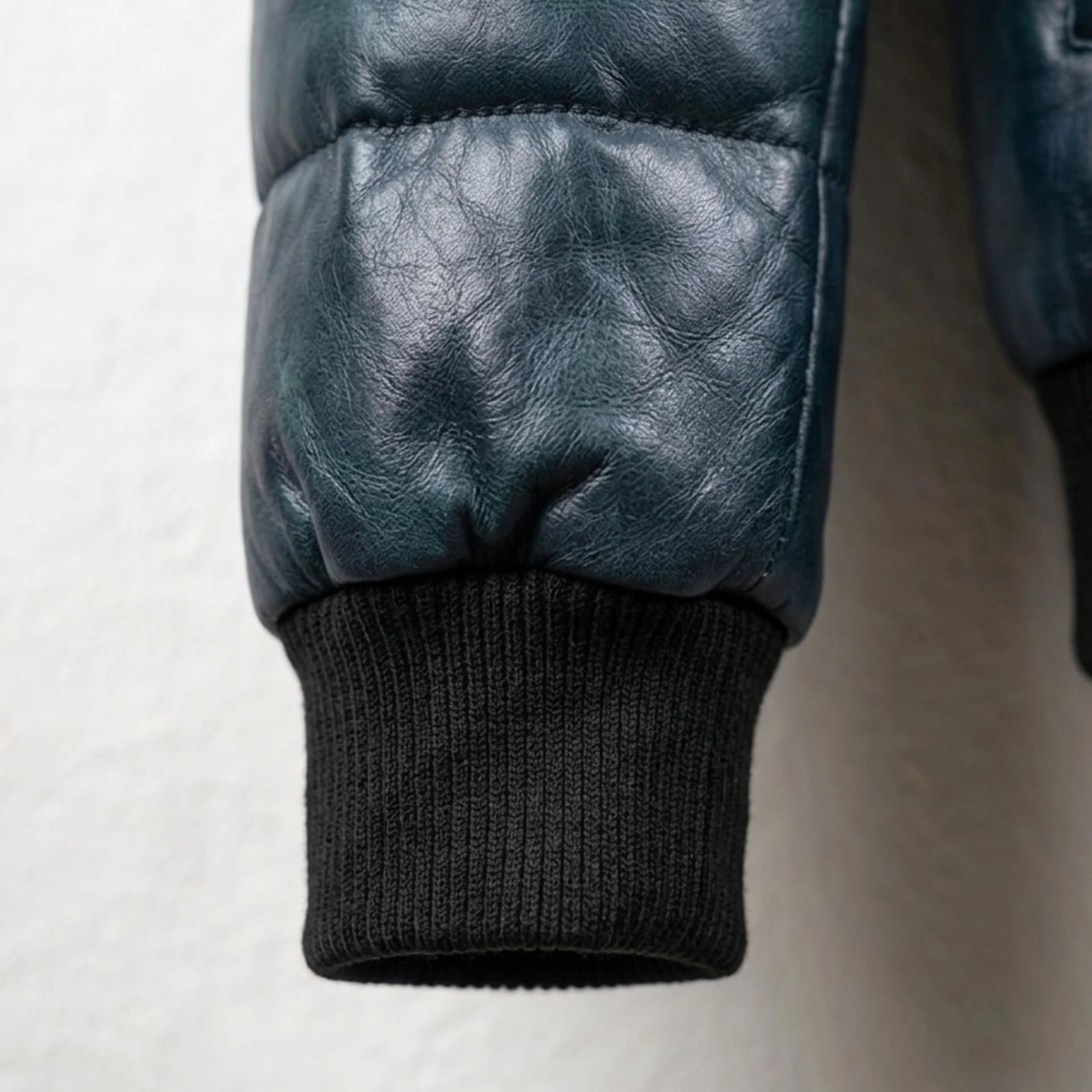 Detailed view of ribbed cuff on genuine lambskin puffer bomber jacket