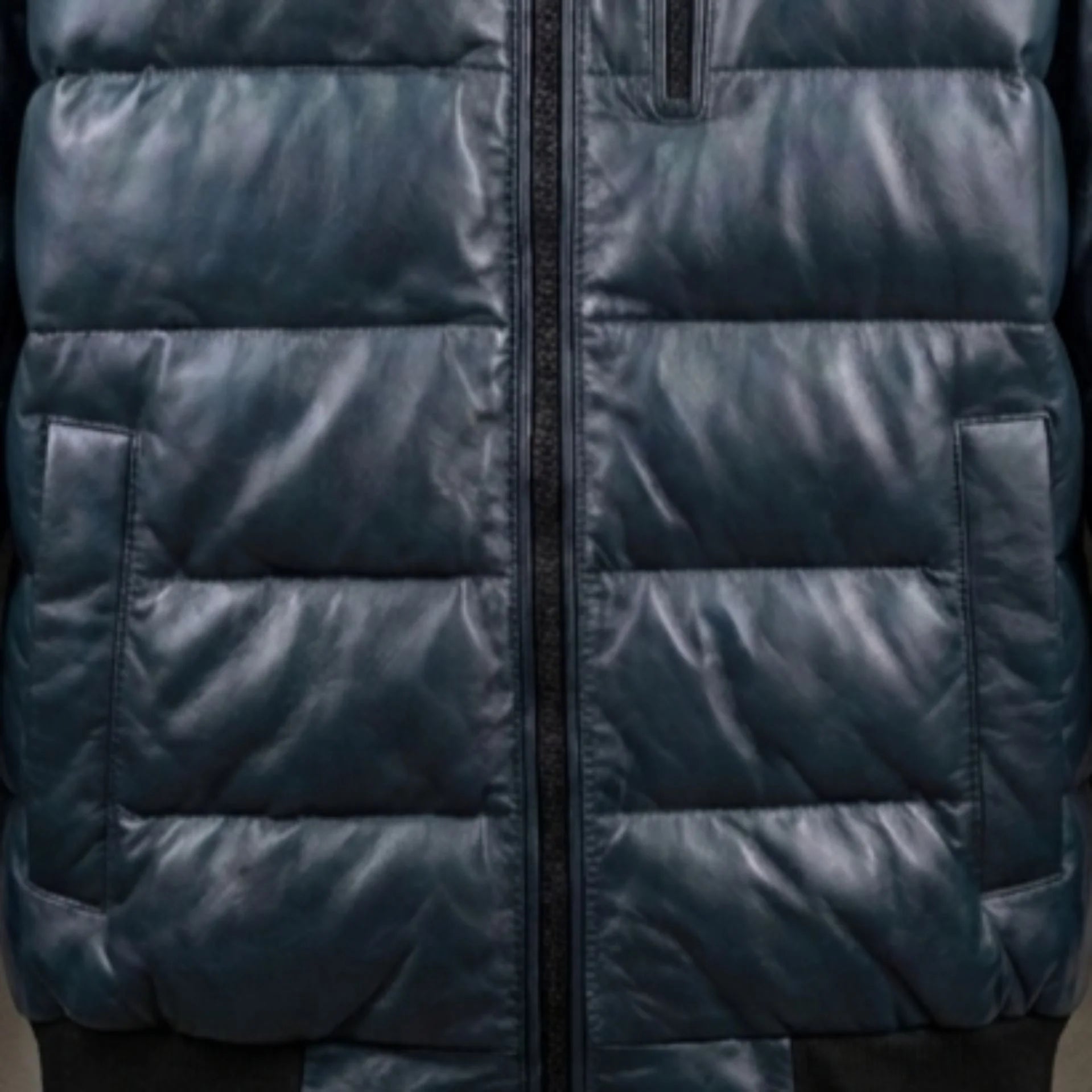 Close-up of chest zip pocket and quilted texture on teal leather bomber jacket