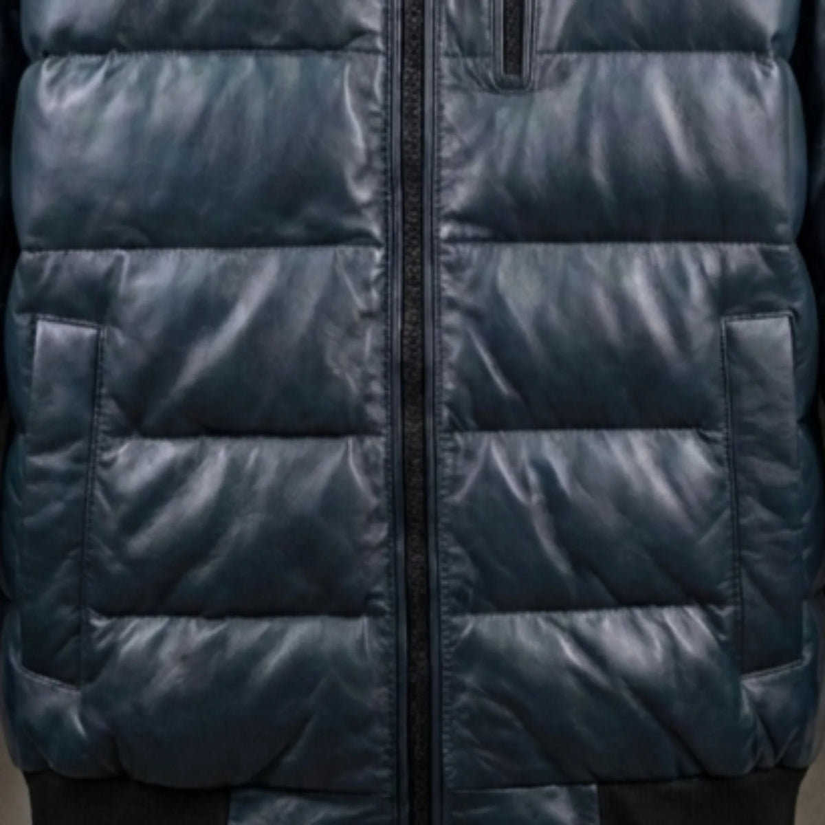 Close-up of chest zip pocket and quilted texture on teal leather bomber jacket