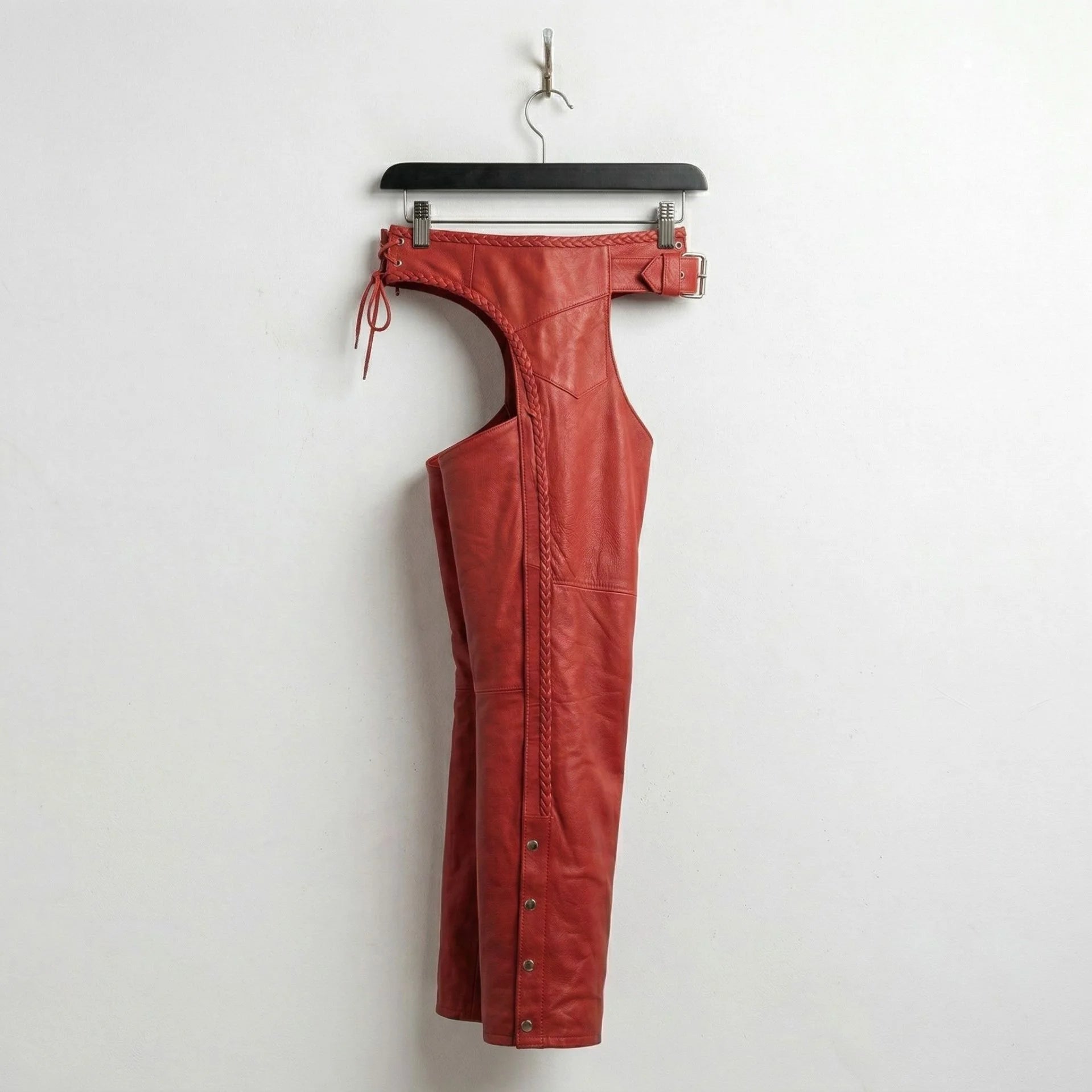 Side profile of red leather motorcycle chaps with snap leg closures