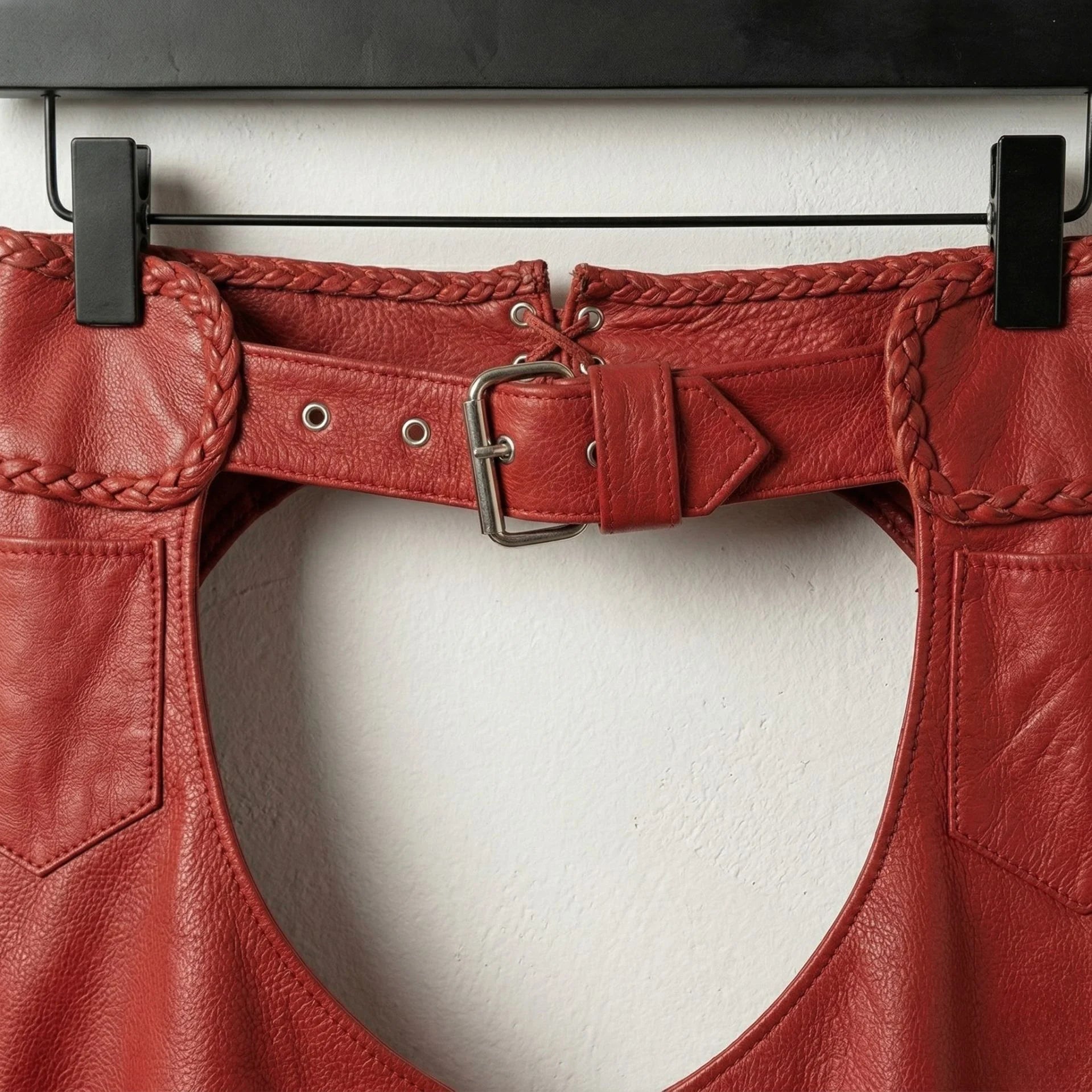 Close up of waist belt, buckle and braided trim on red leather chaps