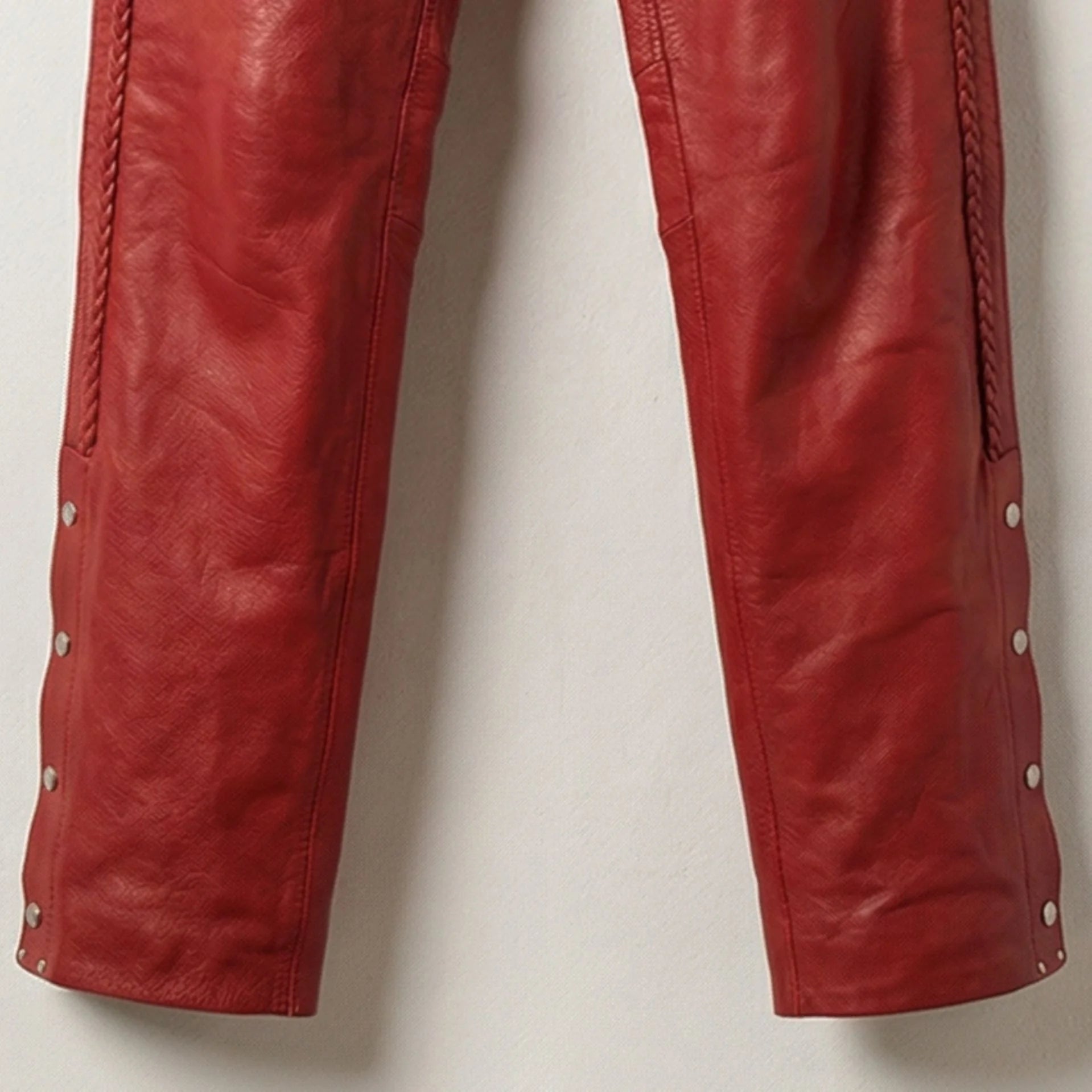 Close up of lower legs and snap buttons on red leather motorcycle chaps