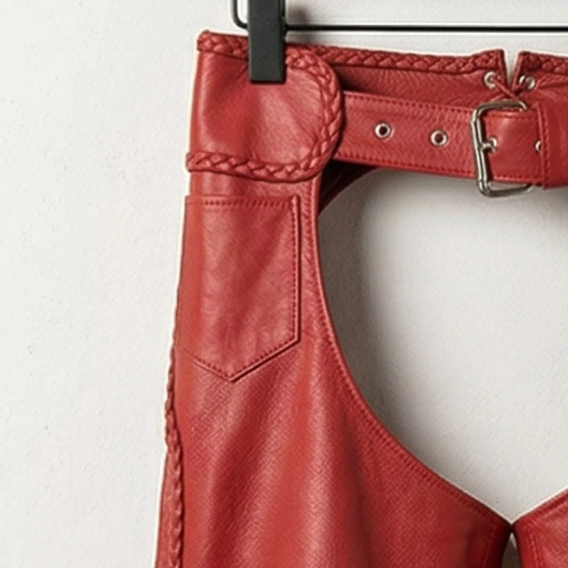 Close up of upper thigh panel and braided side seam on red leather chaps