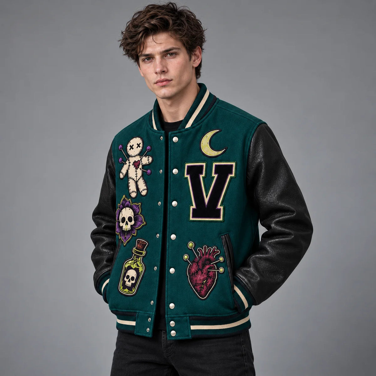 Three-quarter model view showing embroidered teal varsity jacket, black leather sleeves and striped rib-knit trim