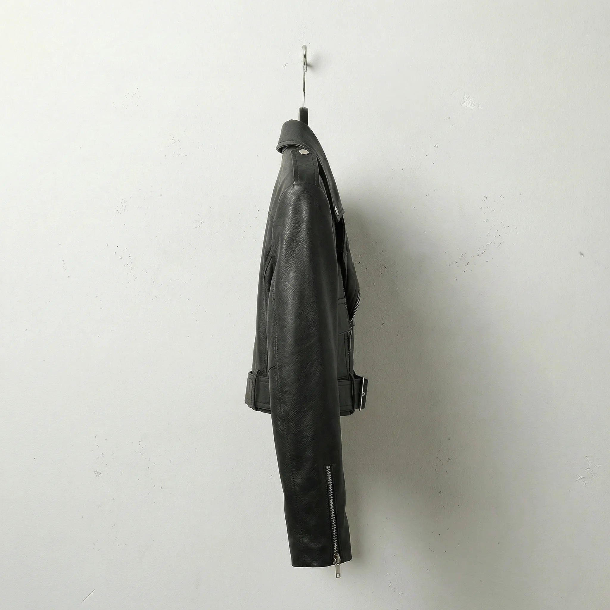 Side profile of women’s black cropped leather biker jacket with belted waist