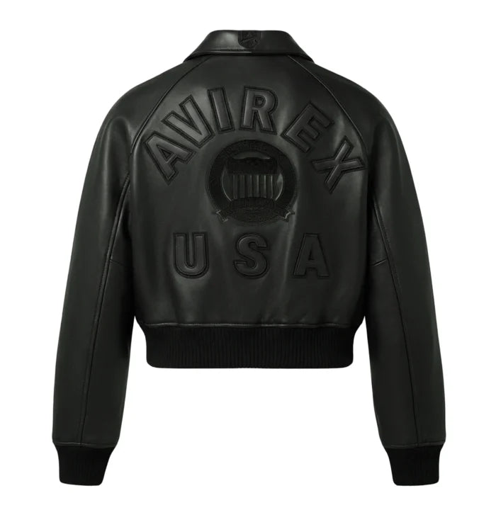 Full back view of women’s black cropped leather bomber jacket with tonal lettering, crest graphics and rib-knit waistband