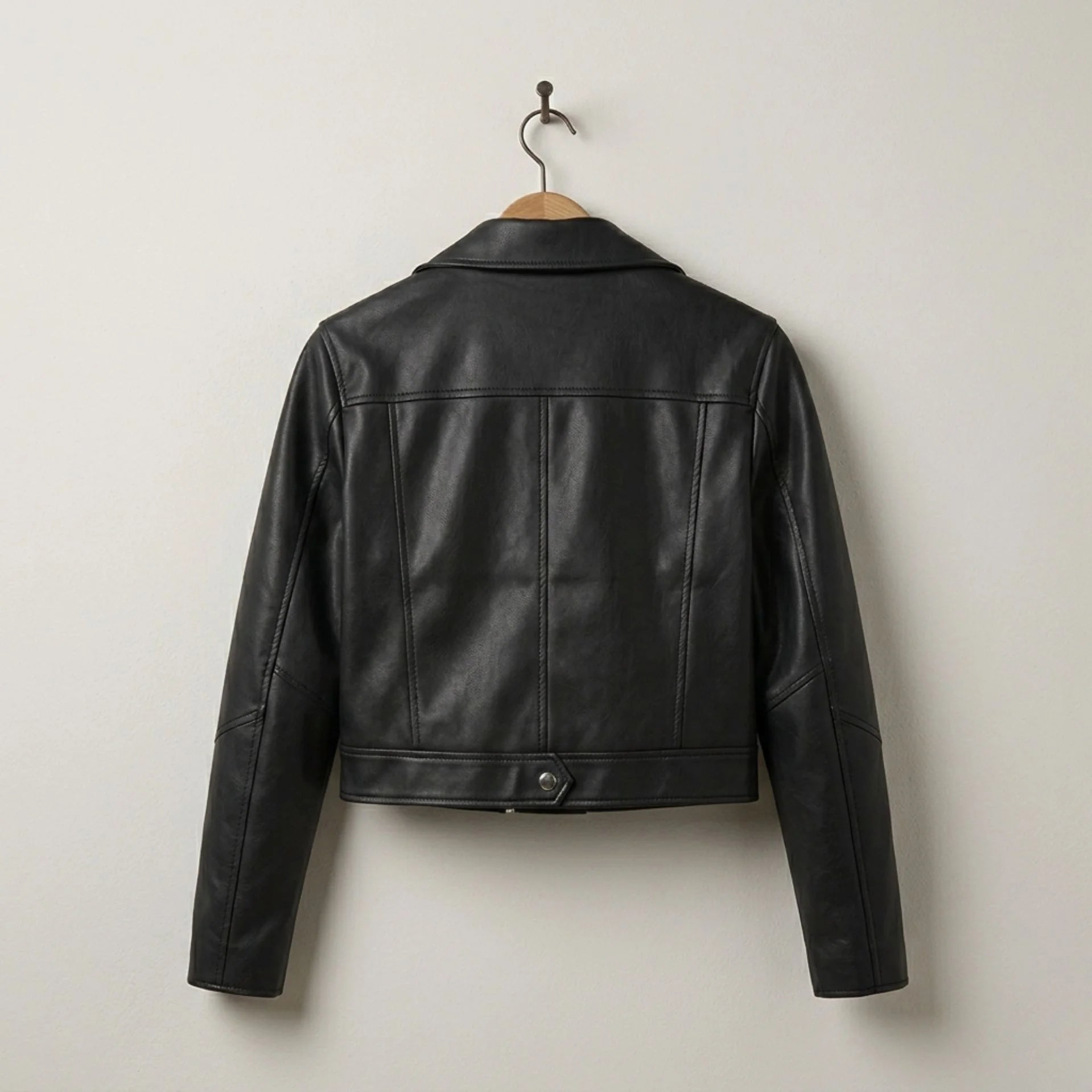 Back view of women’s black cropped leather biker jacket