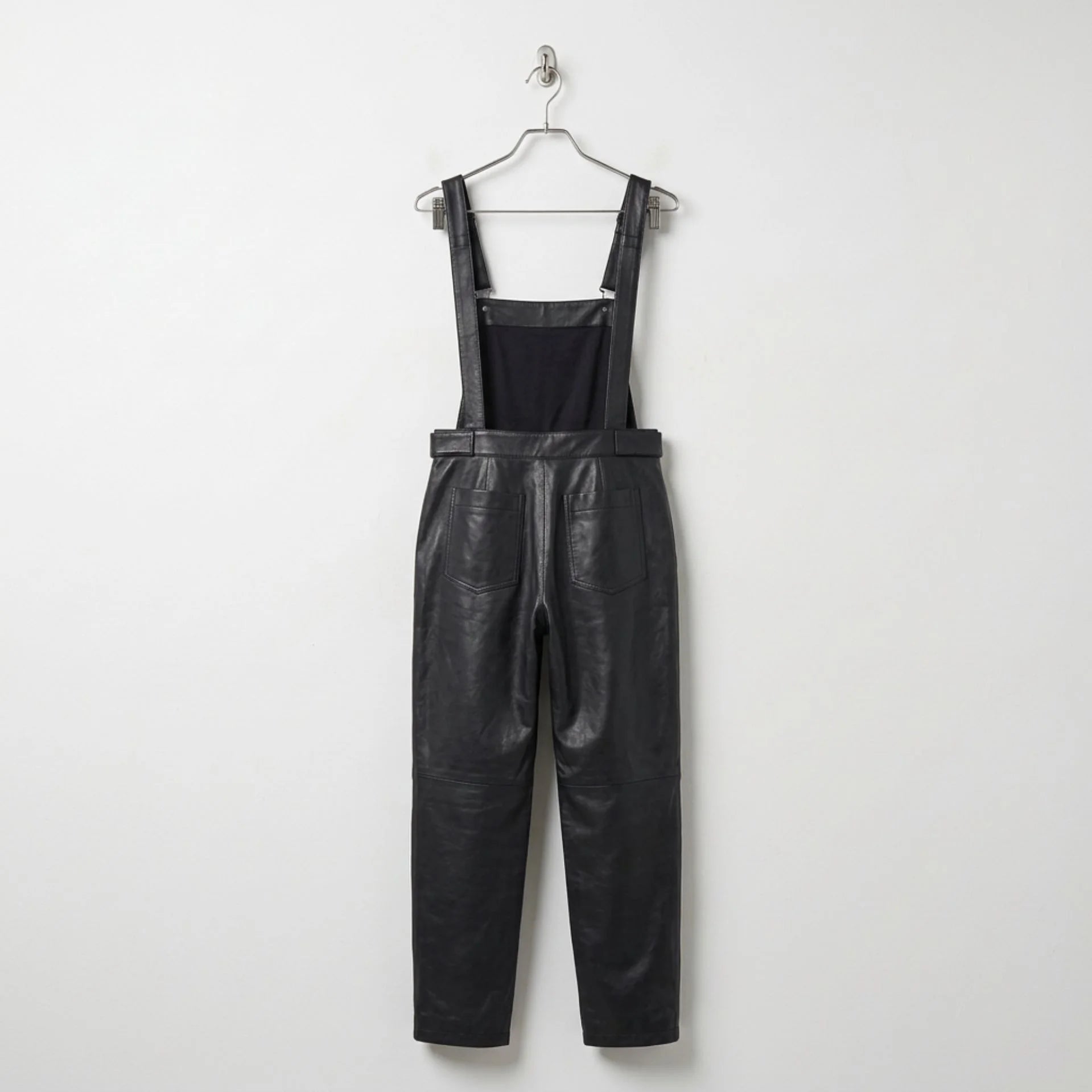 Back view of women’s black leather overalls showing rear pockets