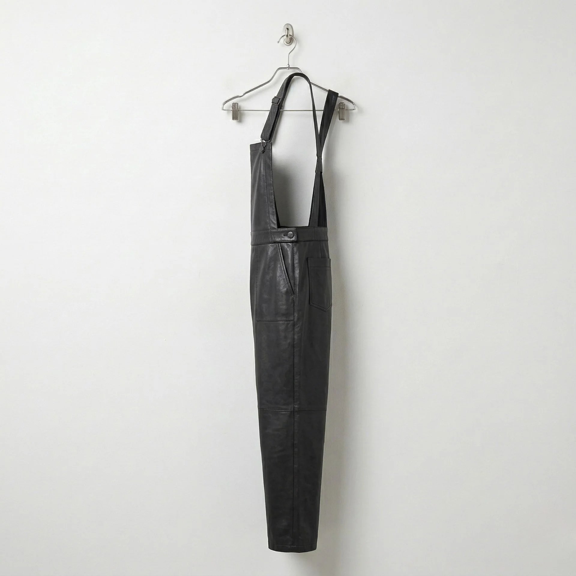 Opposite side view of women’s black leather dungarees