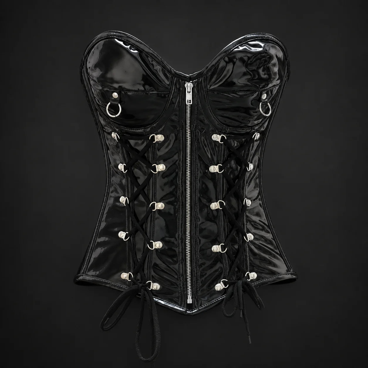 Front product view of black PVC overbust corset with silver-tone centre zip, ring accents and symmetrical lace detailing