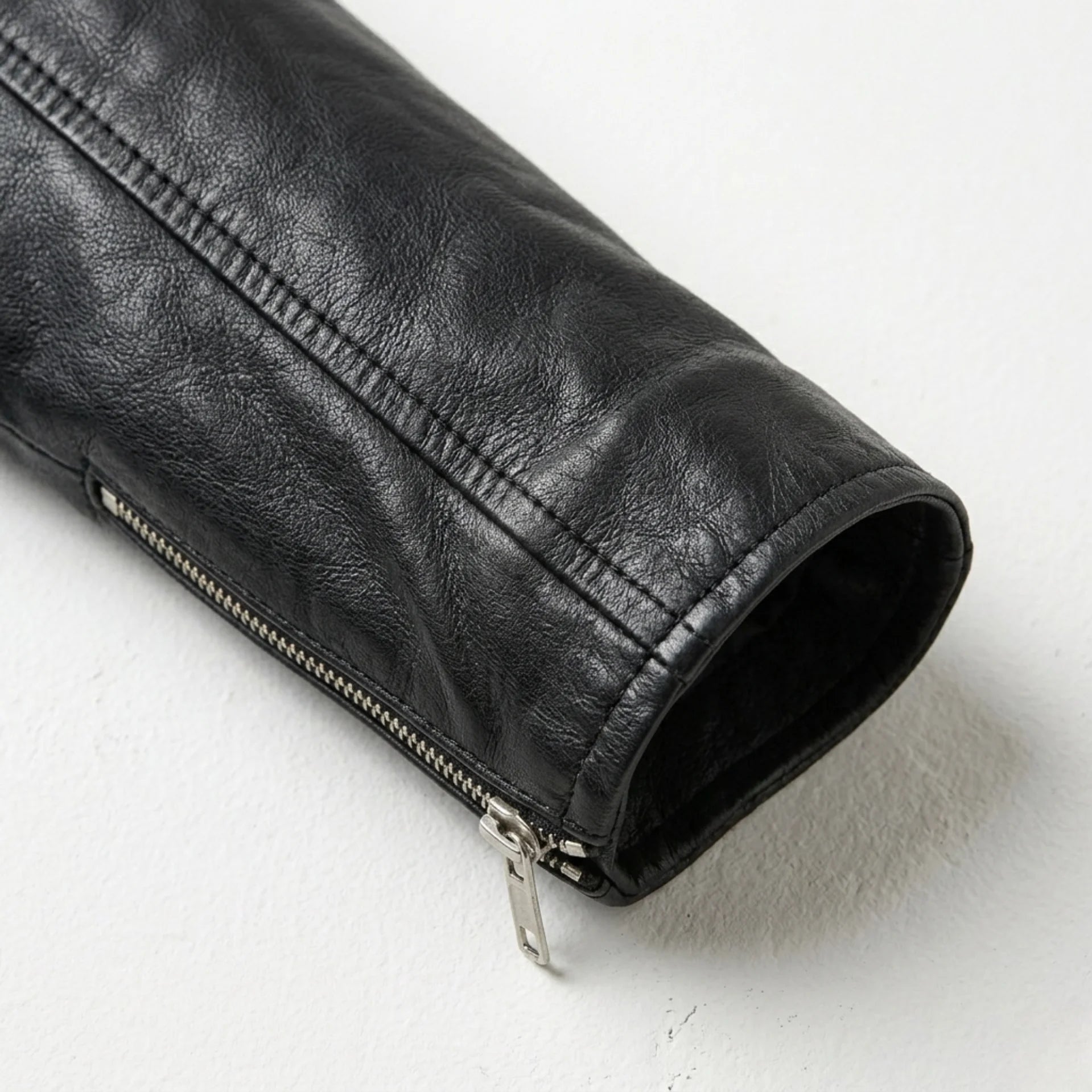 Sleeve and zipper cuff detail on women’s black leather biker jacket
