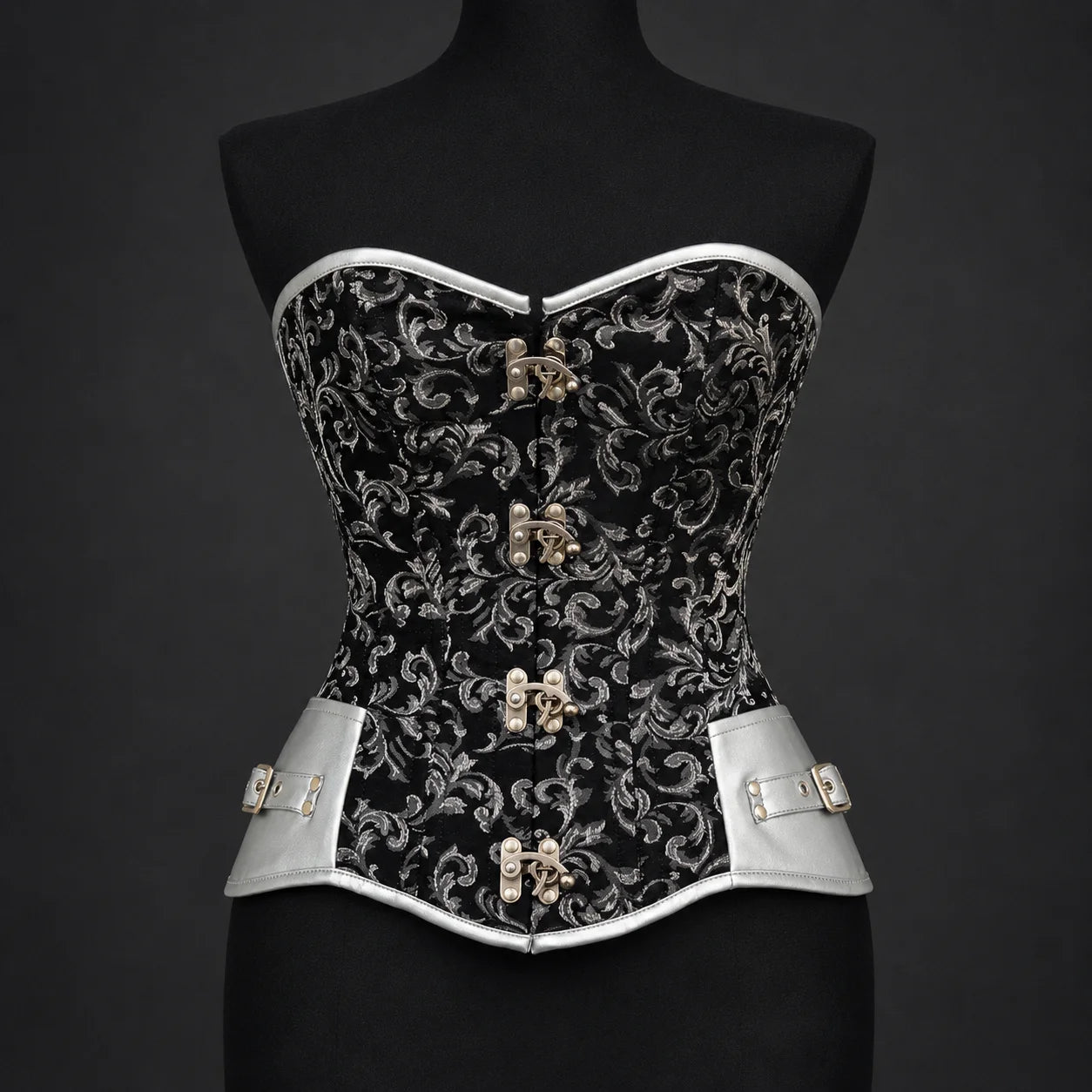 Front studio view of black silver overbust corset showing floral pattern, silver trim and four decorative clasps