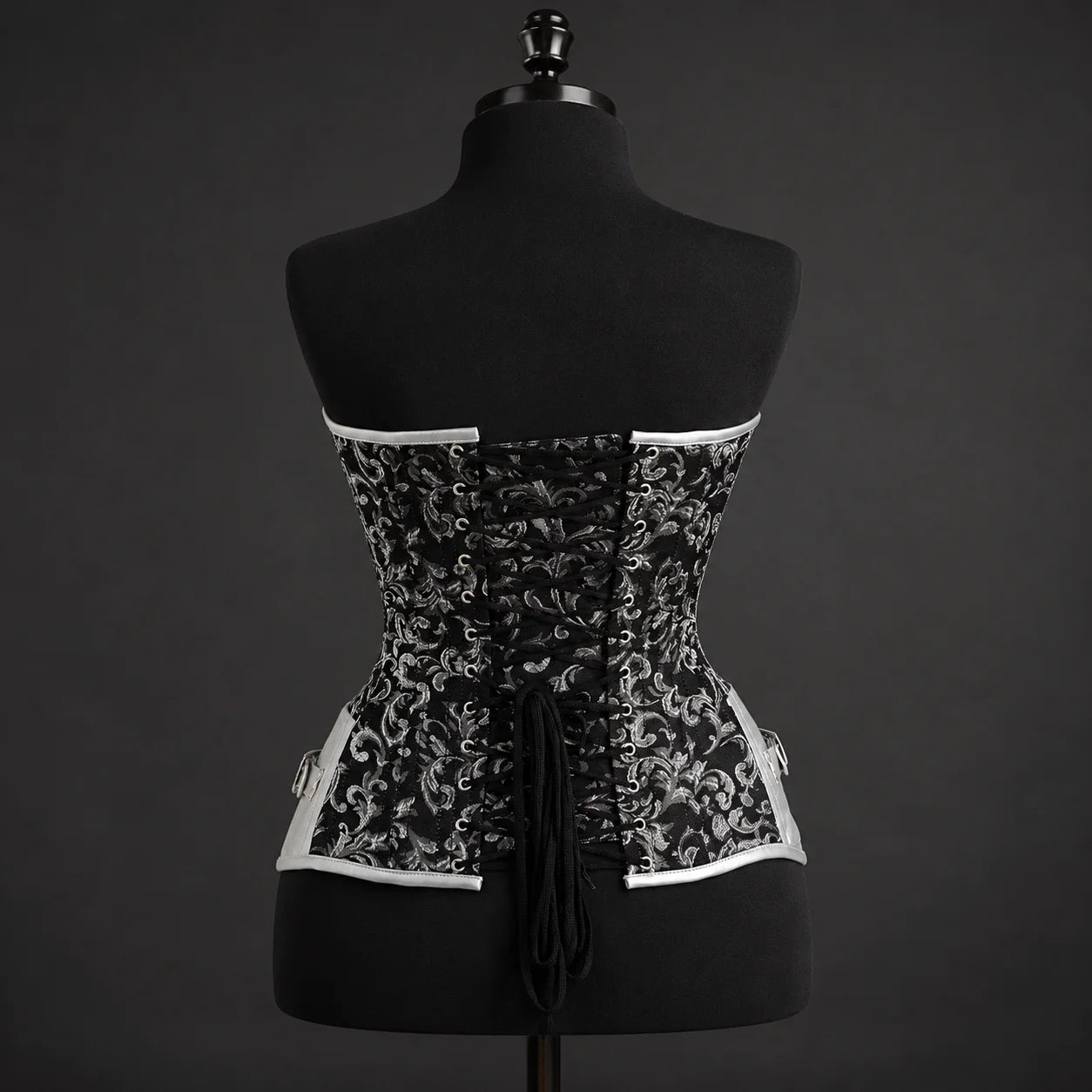 Back studio view of gothic black and silver corset with adjustable criss-cross lacing and shaped lower edge