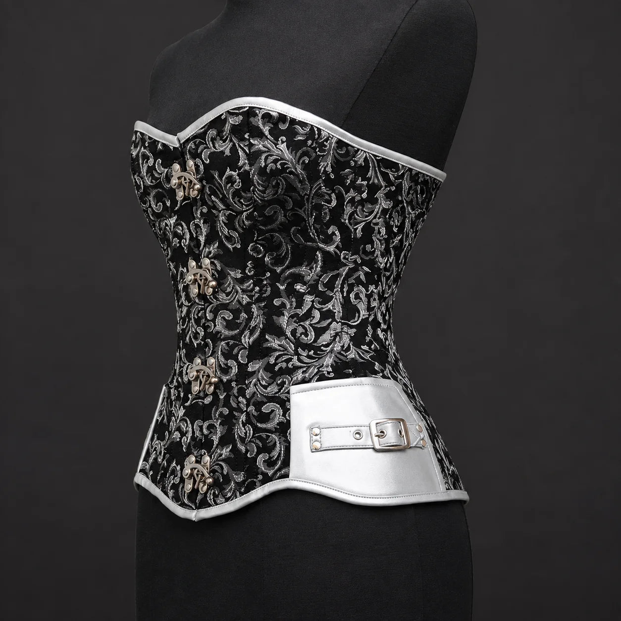 Three-quarter product view of black silver corset highlighting silver faux leather side panel and buckle accent