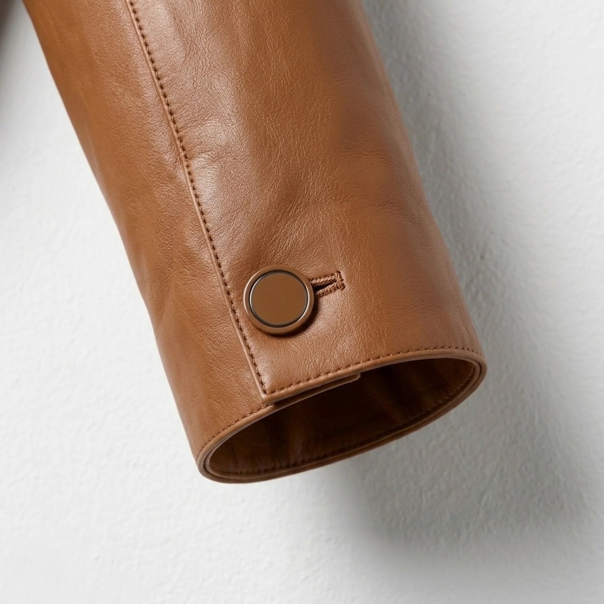 Sleeve and cuff button detail on women’s brown leather jacket
