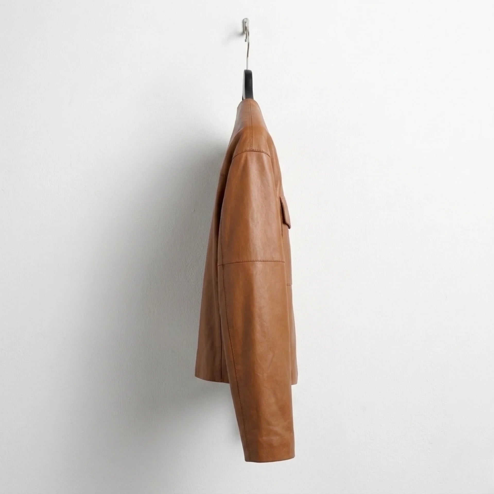 Side profile of women’s brown lambskin collarless leather jacket