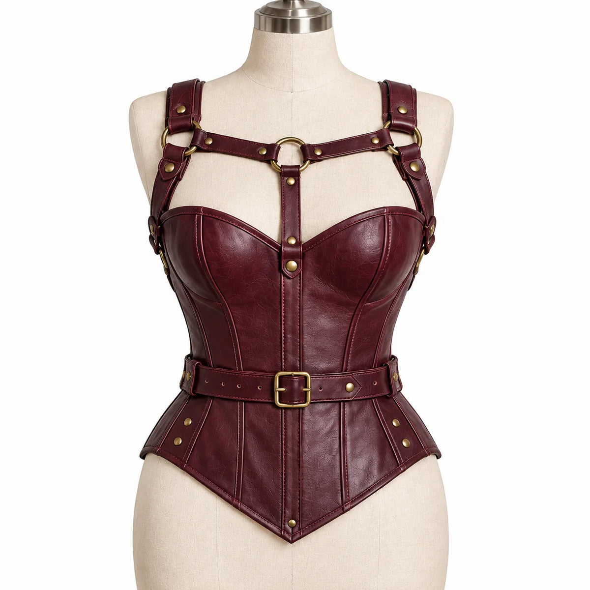 Front mannequin view of burgundy cowhide leather overbust corset with gold-tone chest harness, waist belt and pointed hem.