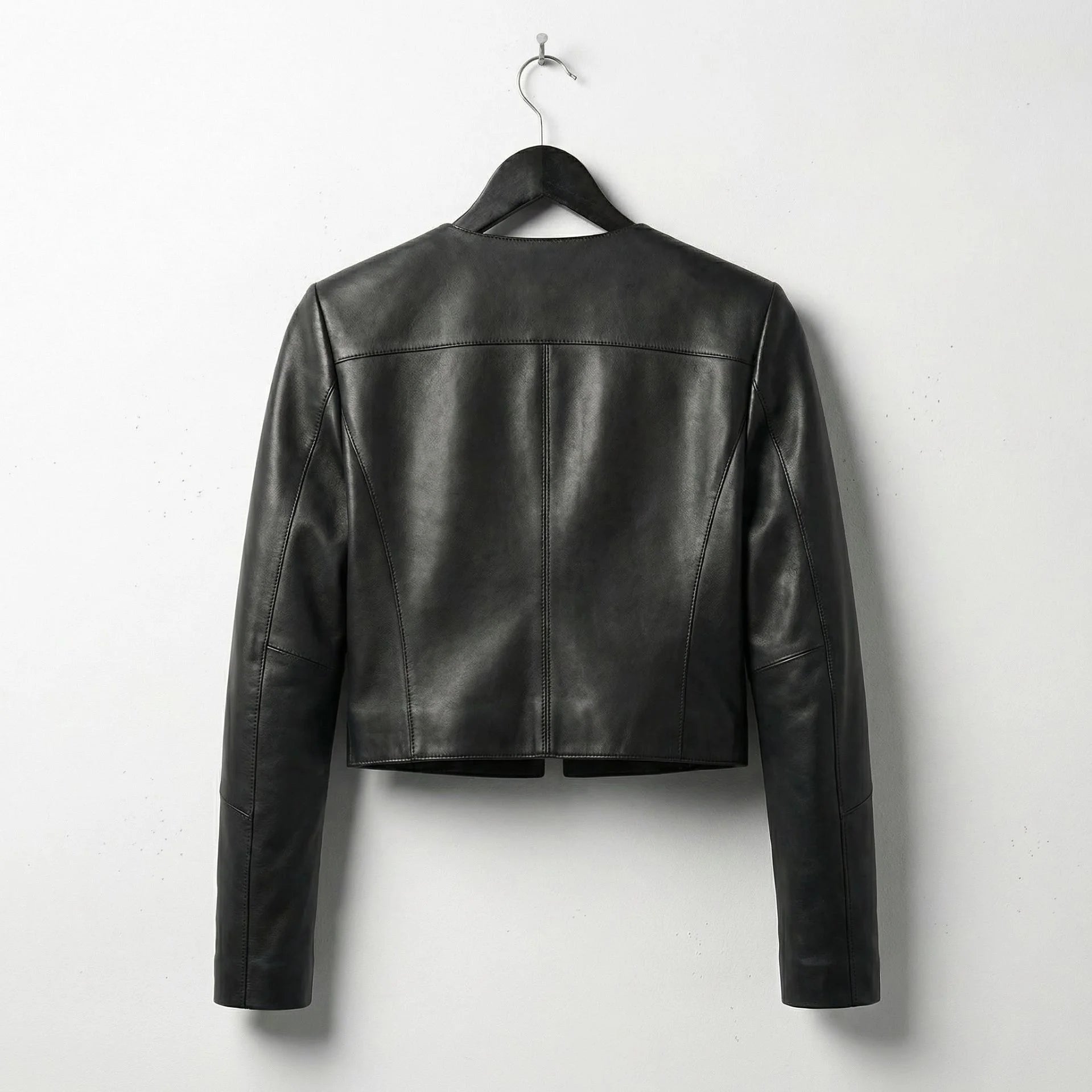Back view of women's cropped black leather leather jacket showing clean seams