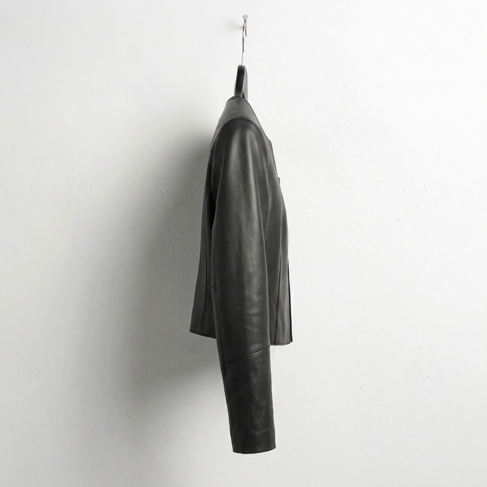 Side profile of minimalist women's cropped leather jacket