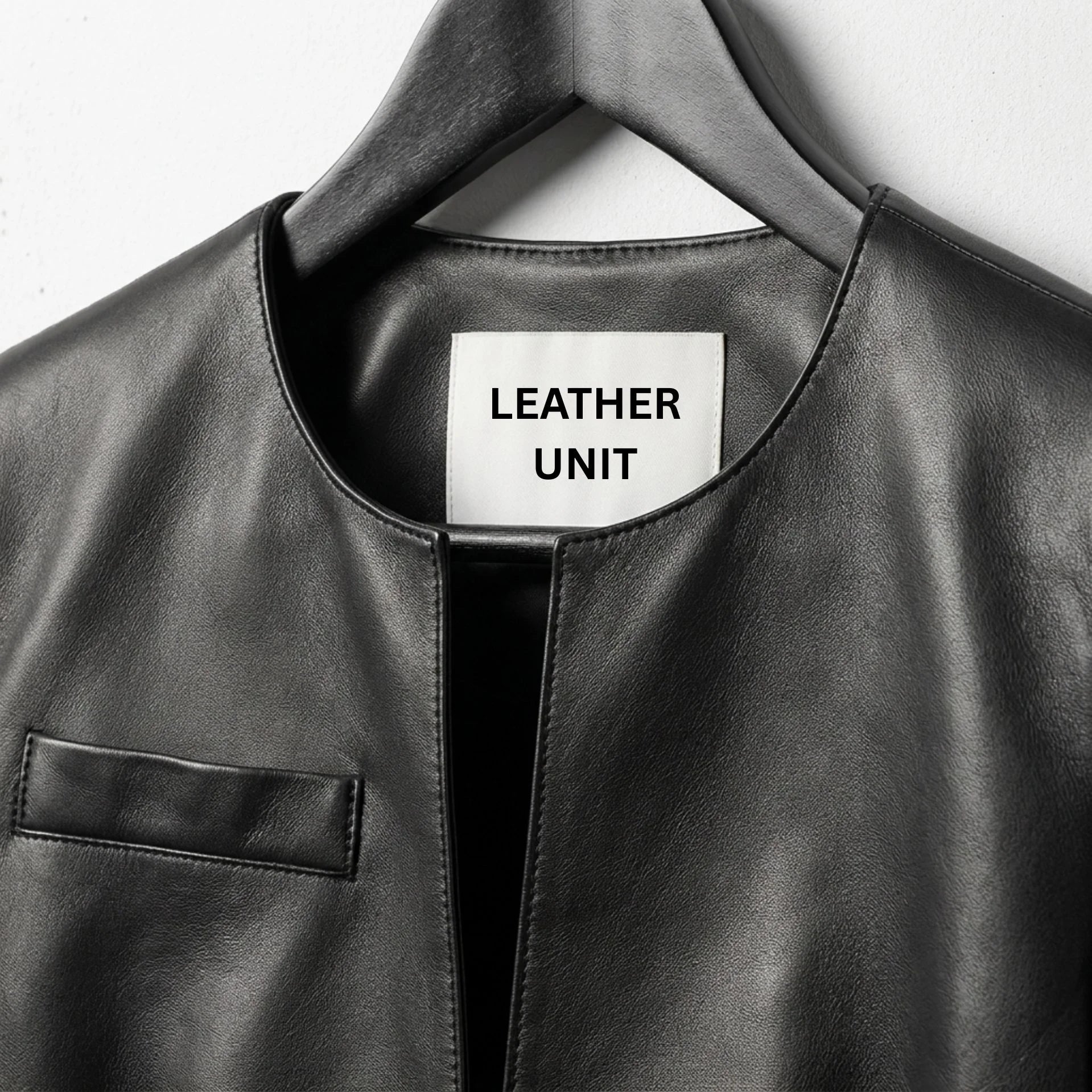 Close-up of neckline and Leather Unit label on women's black leather jacket